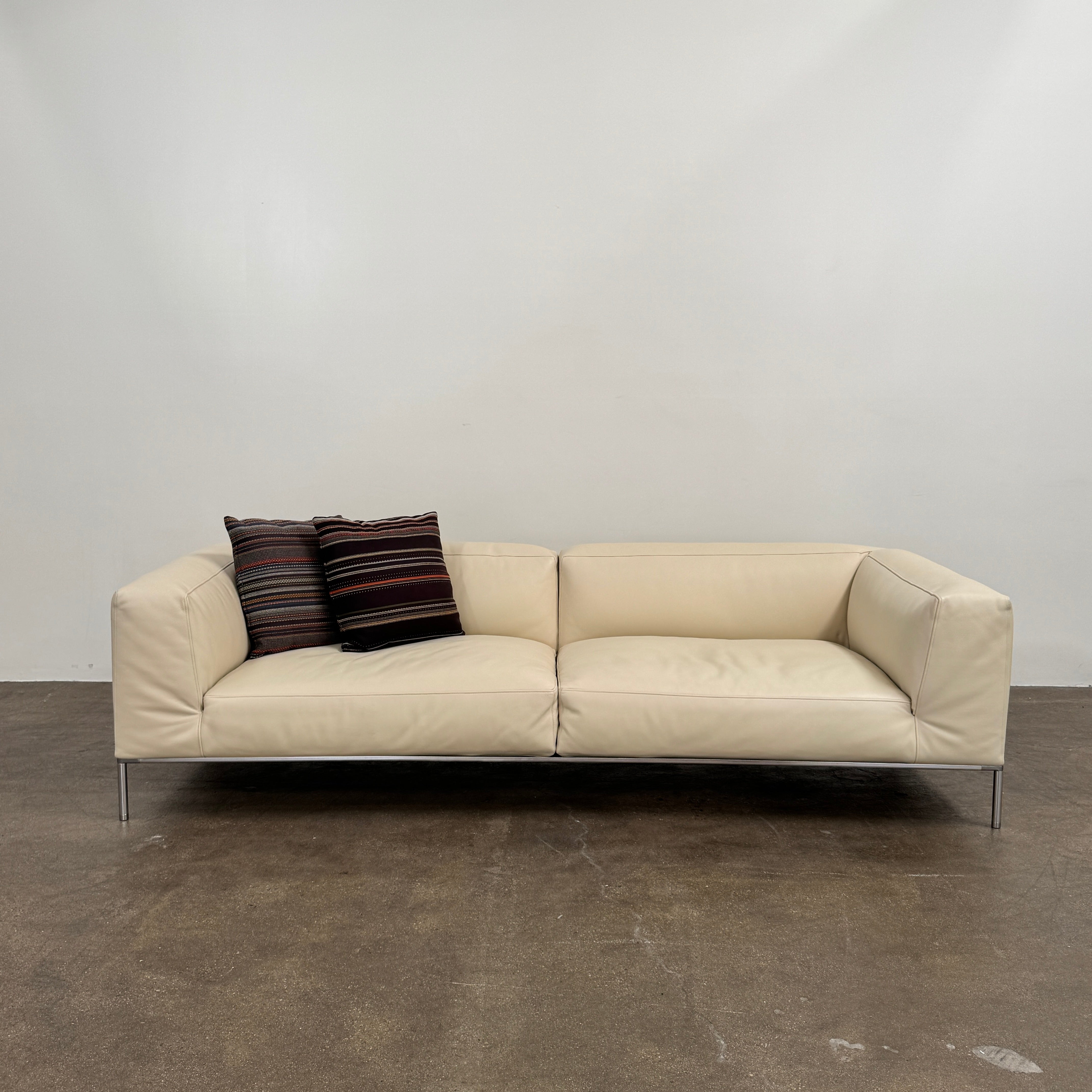 A beige B&B Italia Frank Sofa by B&B Italia, featuring metal legs and a minimalist modern design, is set against a plain white background.