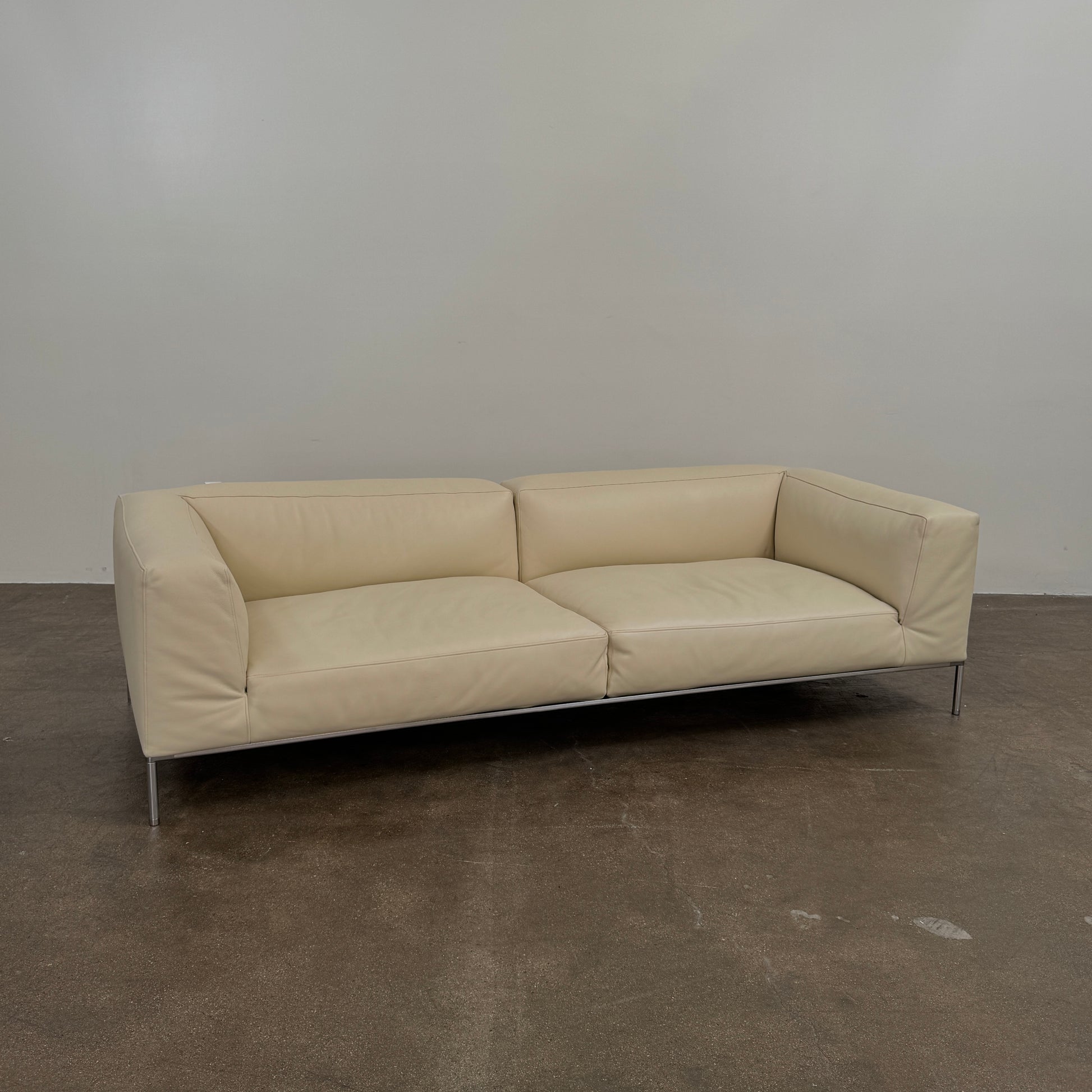 A beige B&B Italia Frank Sofa by B&B Italia, featuring metal legs and a minimalist modern design, is set against a plain white background.