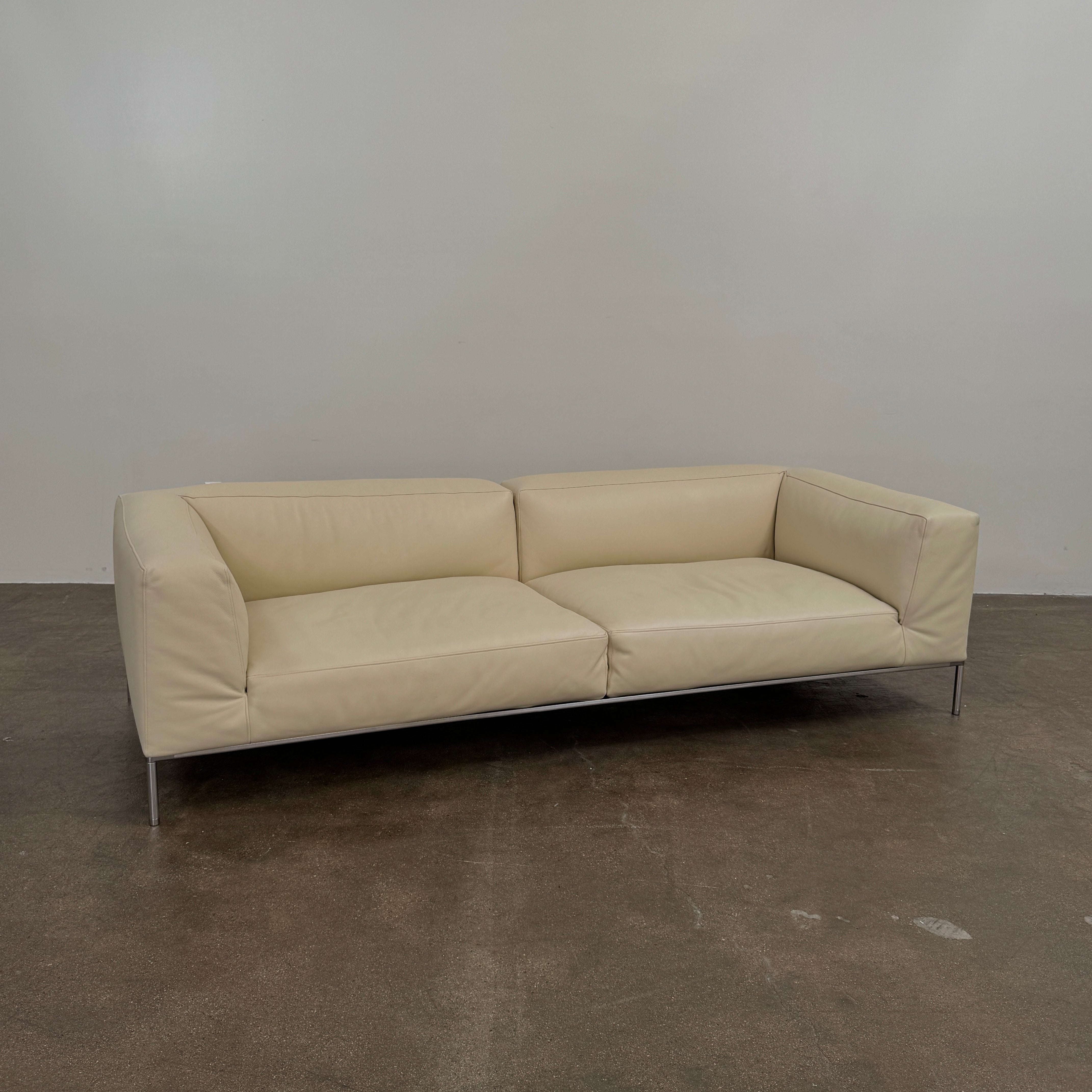 A beige B&B Italia Frank Sofa by B&B Italia, featuring metal legs and a minimalist modern design, is set against a plain white background.