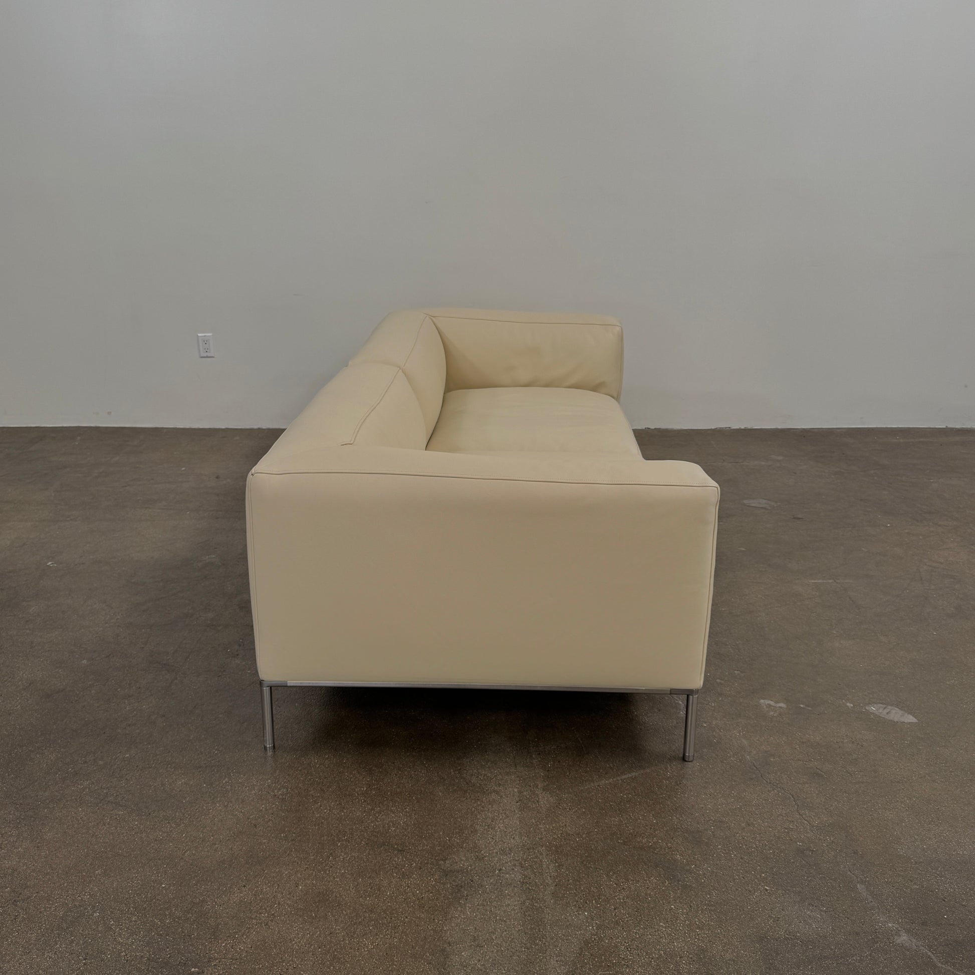 A beige B&B Italia Frank Sofa by B&B Italia, featuring metal legs and a minimalist modern design, is set against a plain white background.
