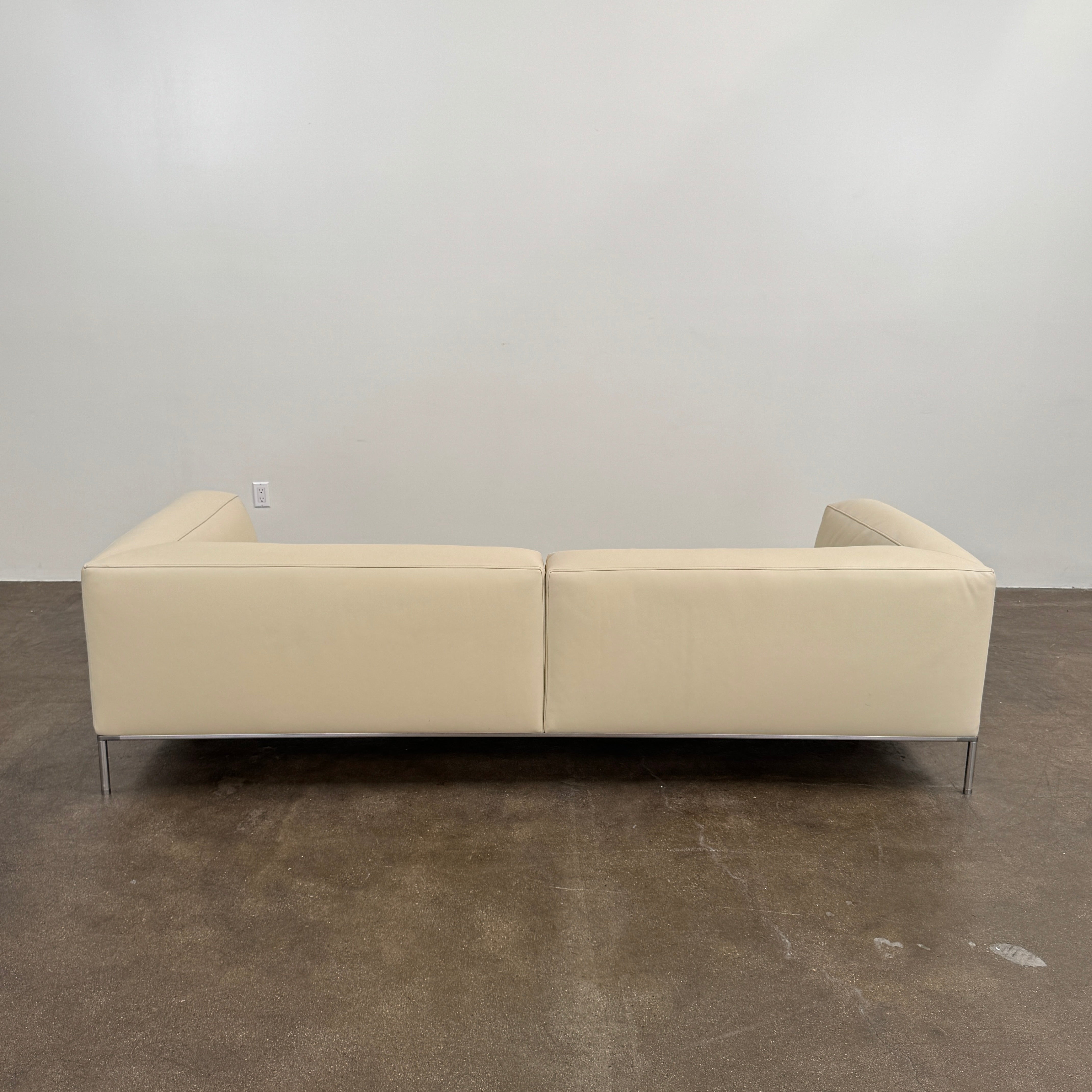A beige B&B Italia Frank Sofa by B&B Italia, featuring metal legs and a minimalist modern design, is set against a plain white background.