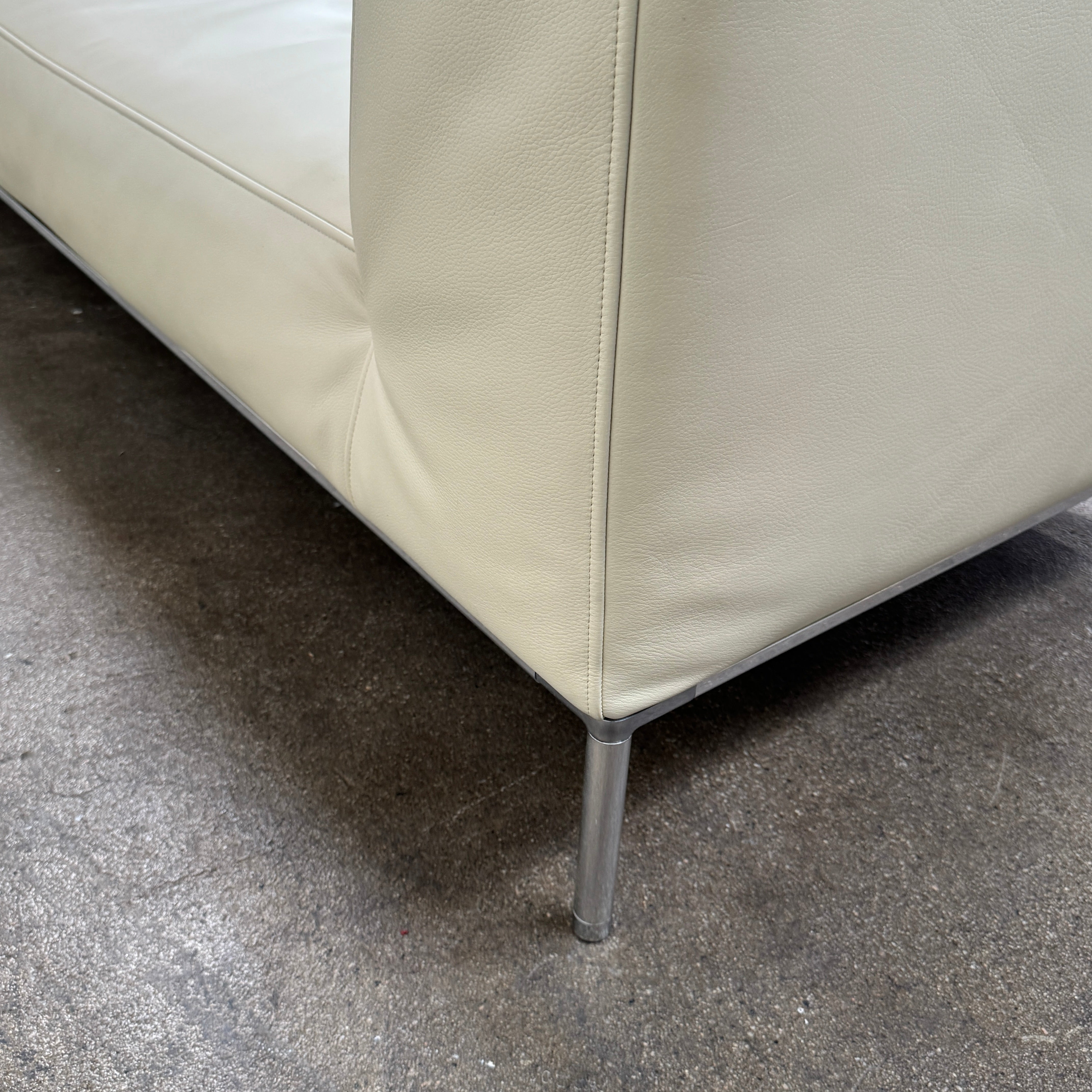 A beige B&B Italia Frank Sofa by B&B Italia, featuring metal legs and a minimalist modern design, is set against a plain white background.