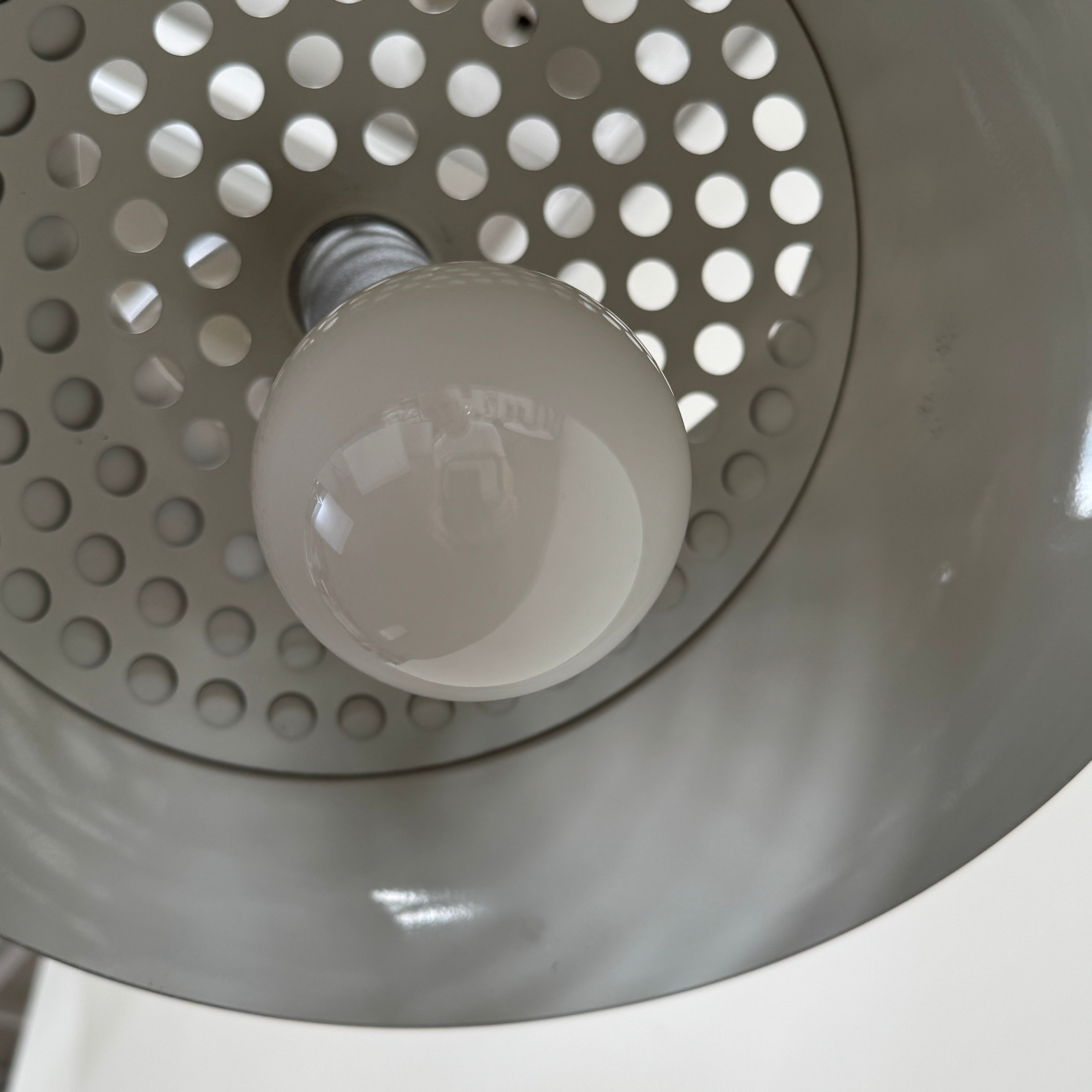 The DWR Arco Floor Lamp by DWR features a marble base, a sleek metal arching stem, and a dome-shaped metal shade; inspired by Italian craftsmanship and Achille Castiglioni’s legendary design, with an electrical cord and plug visible near the base.