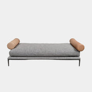 The B&B Italia Atoll Bench with Leather Bolsters by B&B Italia is a modern gray upholstered daybed featuring two cylindrical tan leather bolsters at each end, set on a sleek black metal frame and shown against a white background.