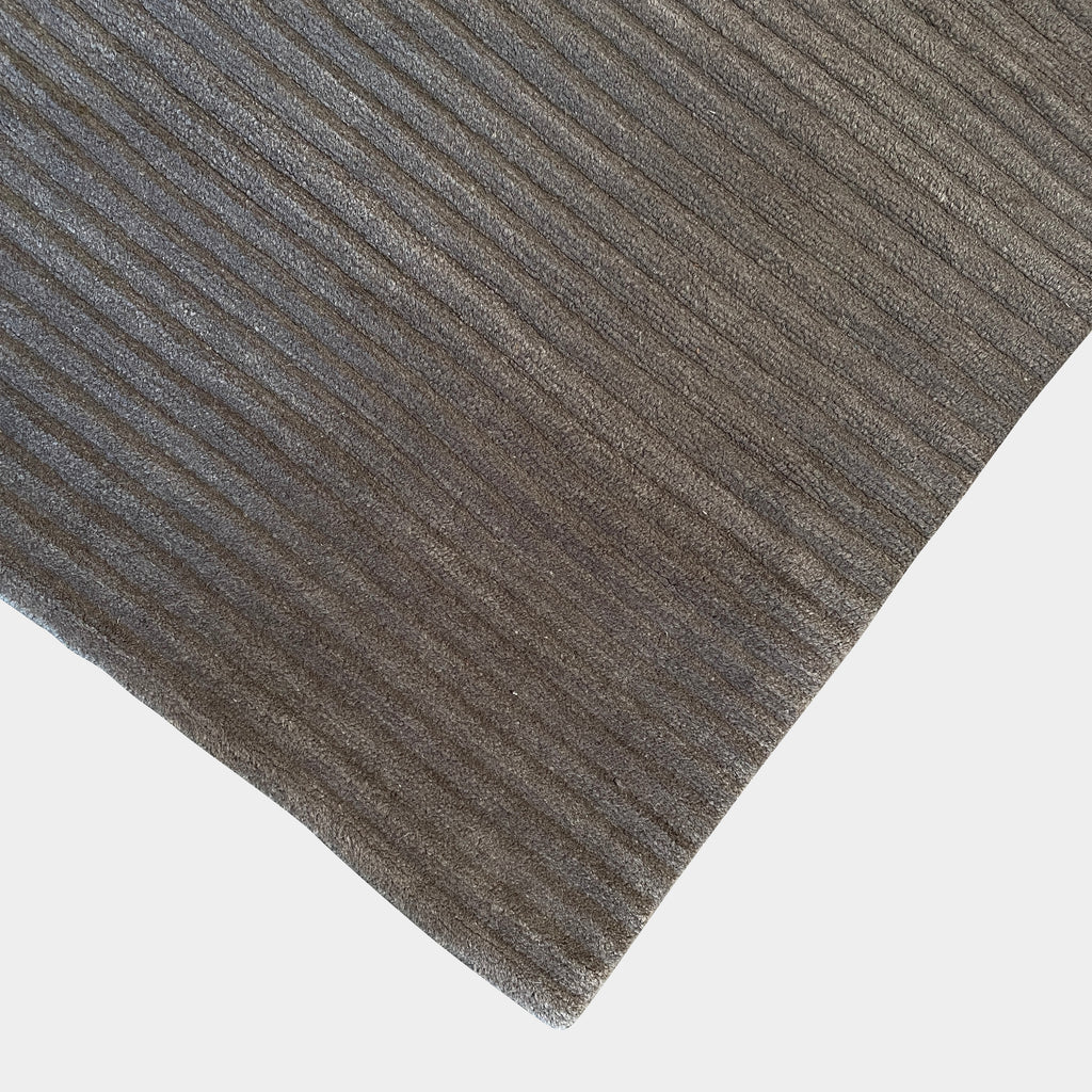 A Delinear wool rug with grey stripes on a white background.