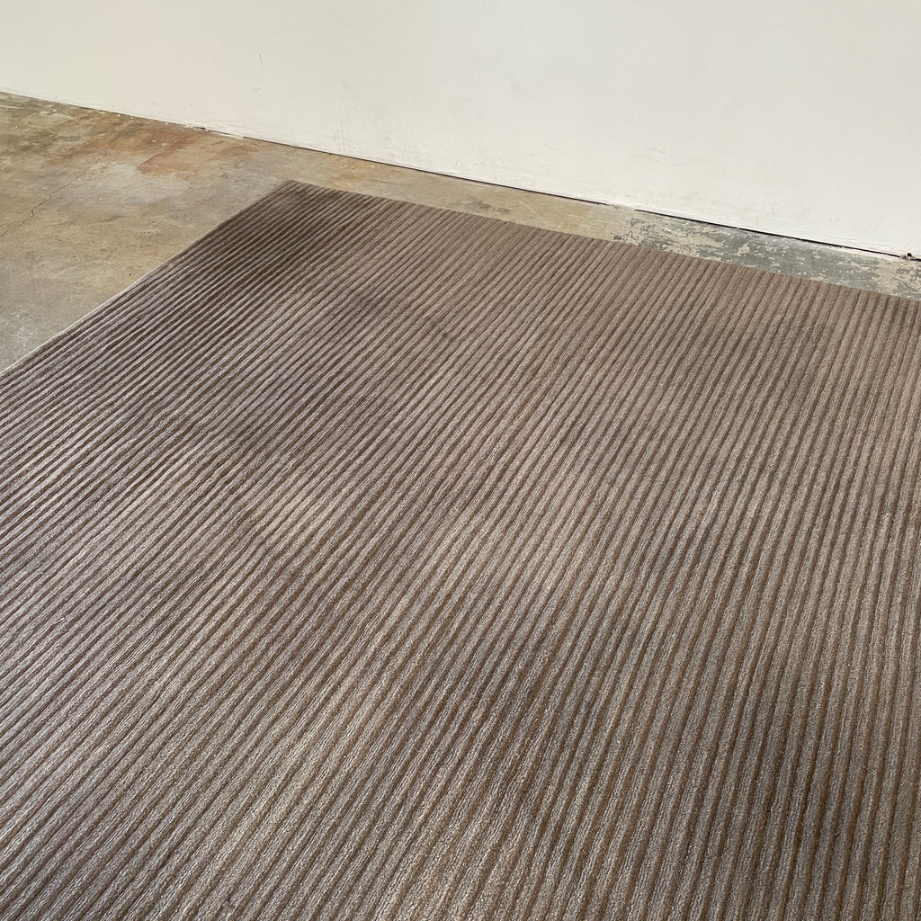A Delinear wool rug with grey stripes on a white background.