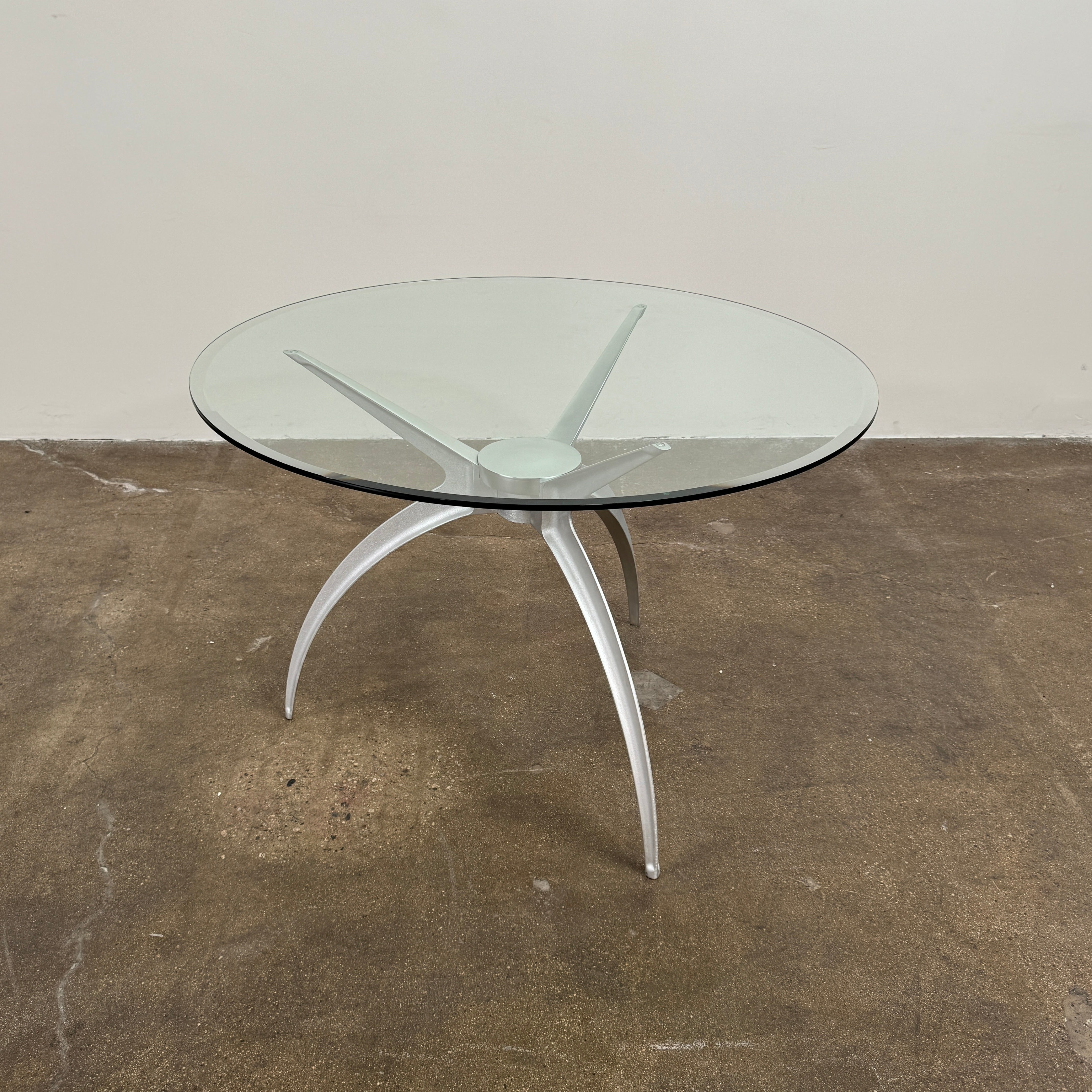 Vintage BD Barcelona Arachnid Table by BD Barcelona, featuring a round glass top and three silver metallic legs, showcased on a plain white background—an eye-catching fusion of modern aesthetics and vintage elegance inspired by Pete Sans.