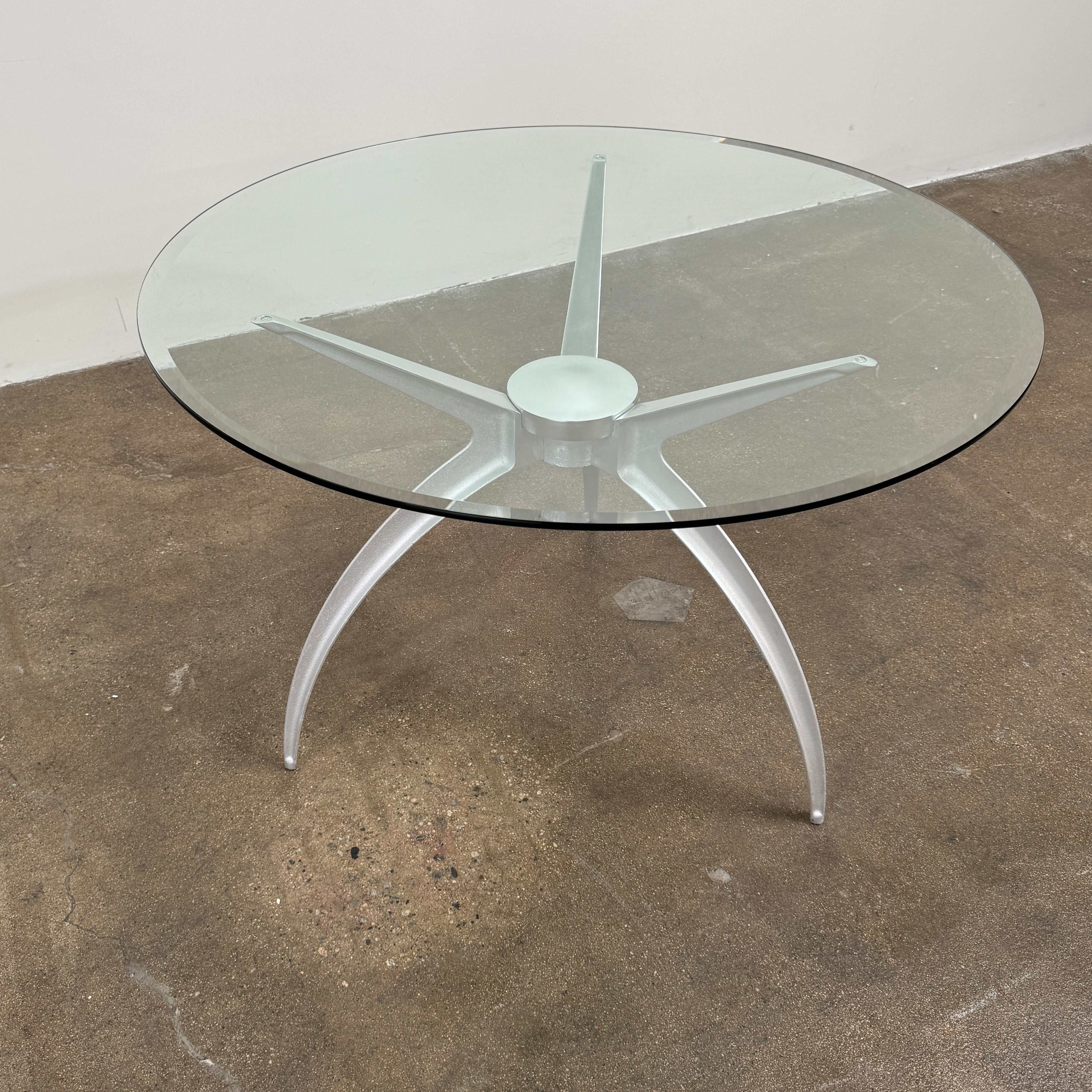 Vintage BD Barcelona Arachnid Table by BD Barcelona, featuring a round glass top and three silver metallic legs, showcased on a plain white background—an eye-catching fusion of modern aesthetics and vintage elegance inspired by Pete Sans.