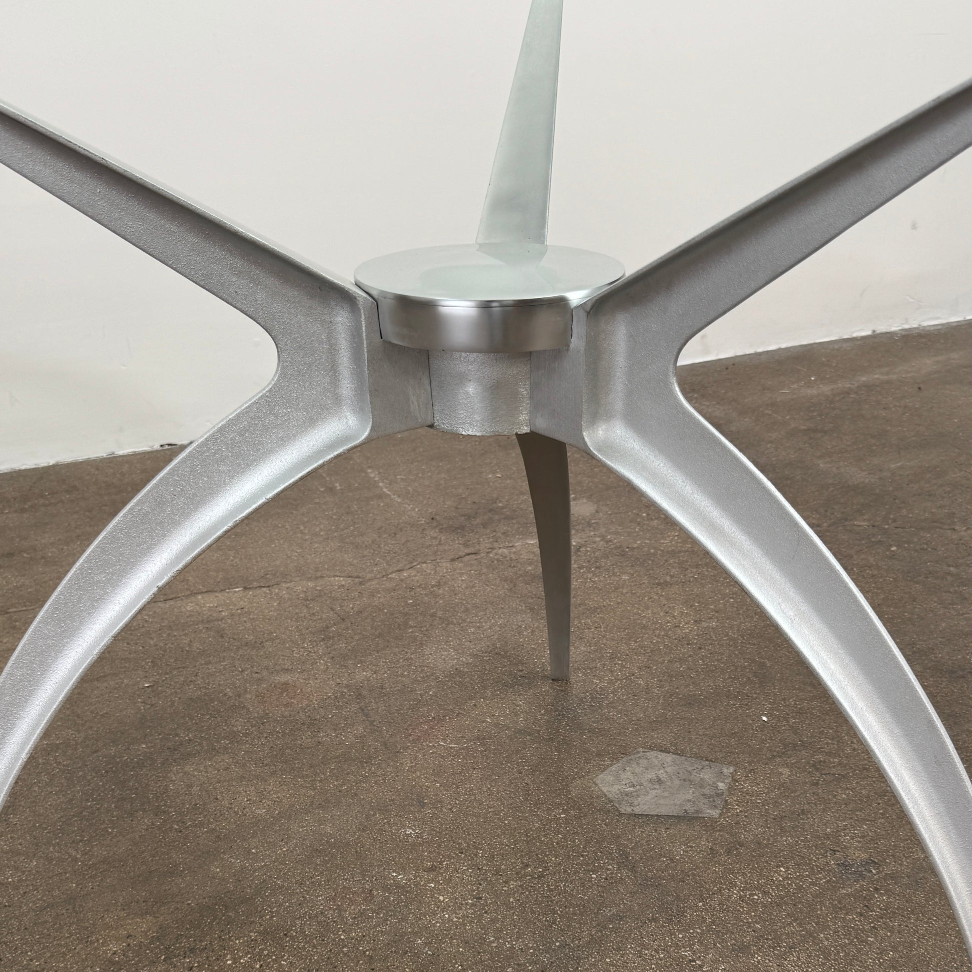 Vintage BD Barcelona Arachnid Table by BD Barcelona, featuring a round glass top and three silver metallic legs, showcased on a plain white background—an eye-catching fusion of modern aesthetics and vintage elegance inspired by Pete Sans.