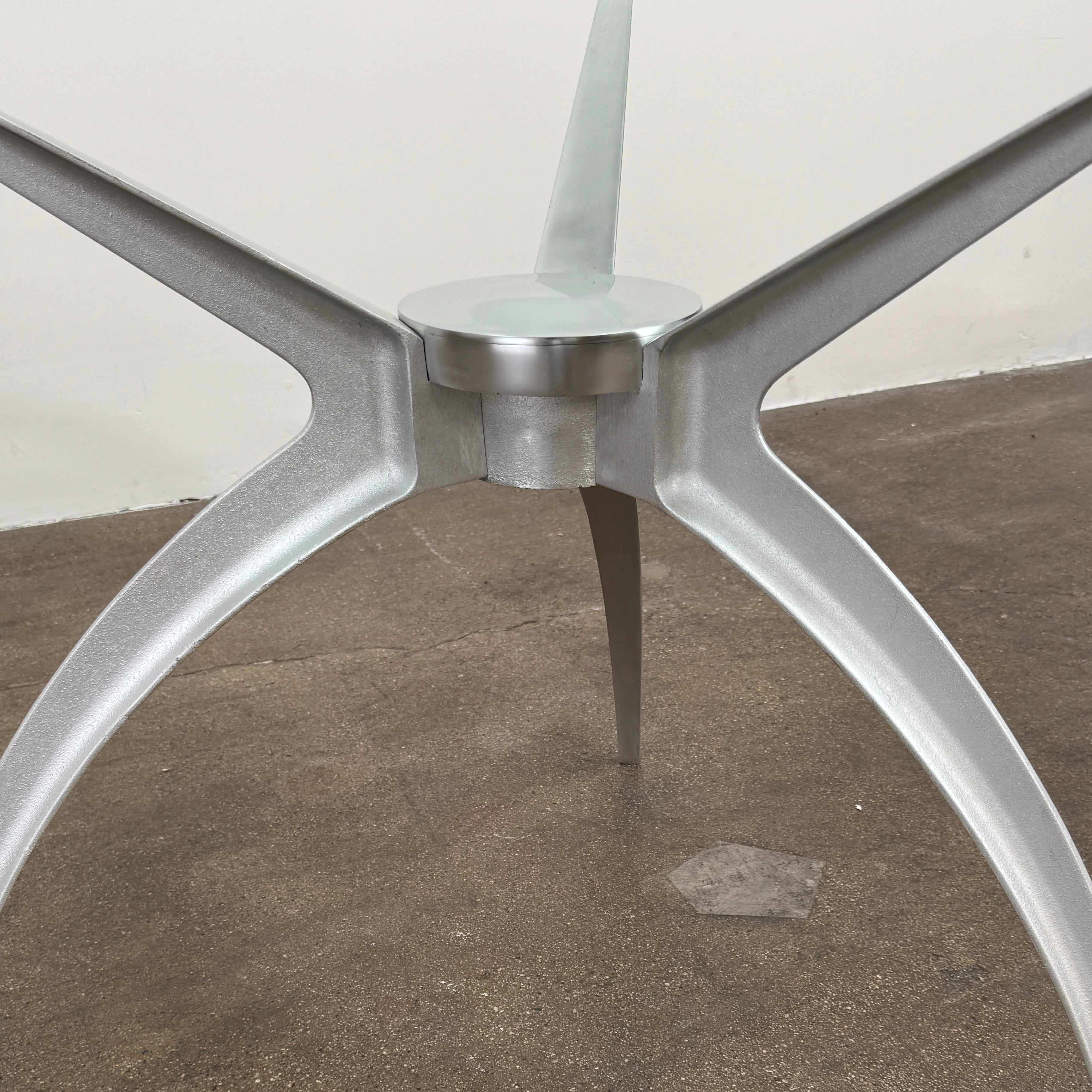 Vintage BD Barcelona Arachnid Table by BD Barcelona, featuring a round glass top and three silver metallic legs, showcased on a plain white background—an eye-catching fusion of modern aesthetics and vintage elegance inspired by Pete Sans.