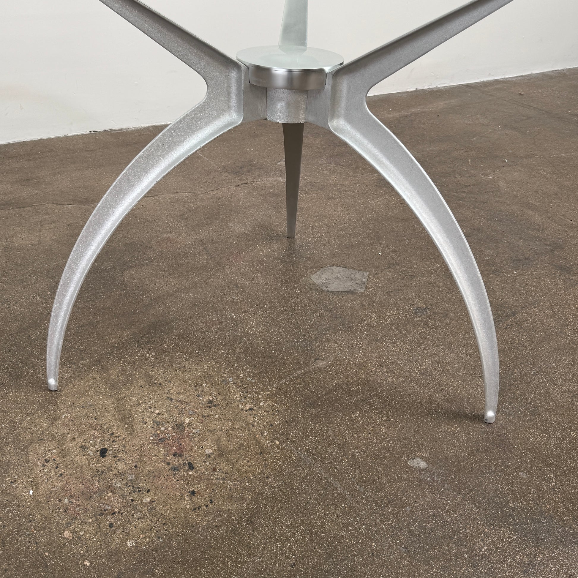 Vintage BD Barcelona Arachnid Table by BD Barcelona, featuring a round glass top and three silver metallic legs, showcased on a plain white background—an eye-catching fusion of modern aesthetics and vintage elegance inspired by Pete Sans.