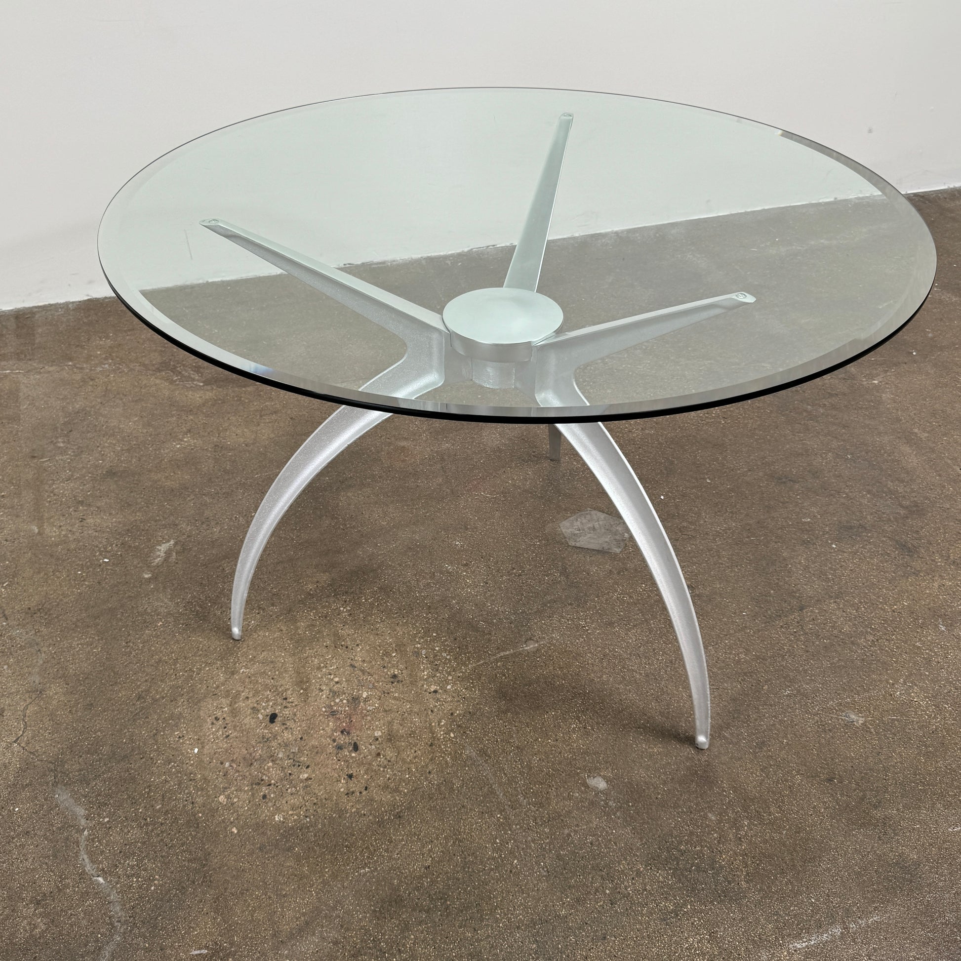 Vintage BD Barcelona Arachnid Table by BD Barcelona, featuring a round glass top and three silver metallic legs, showcased on a plain white background—an eye-catching fusion of modern aesthetics and vintage elegance inspired by Pete Sans.