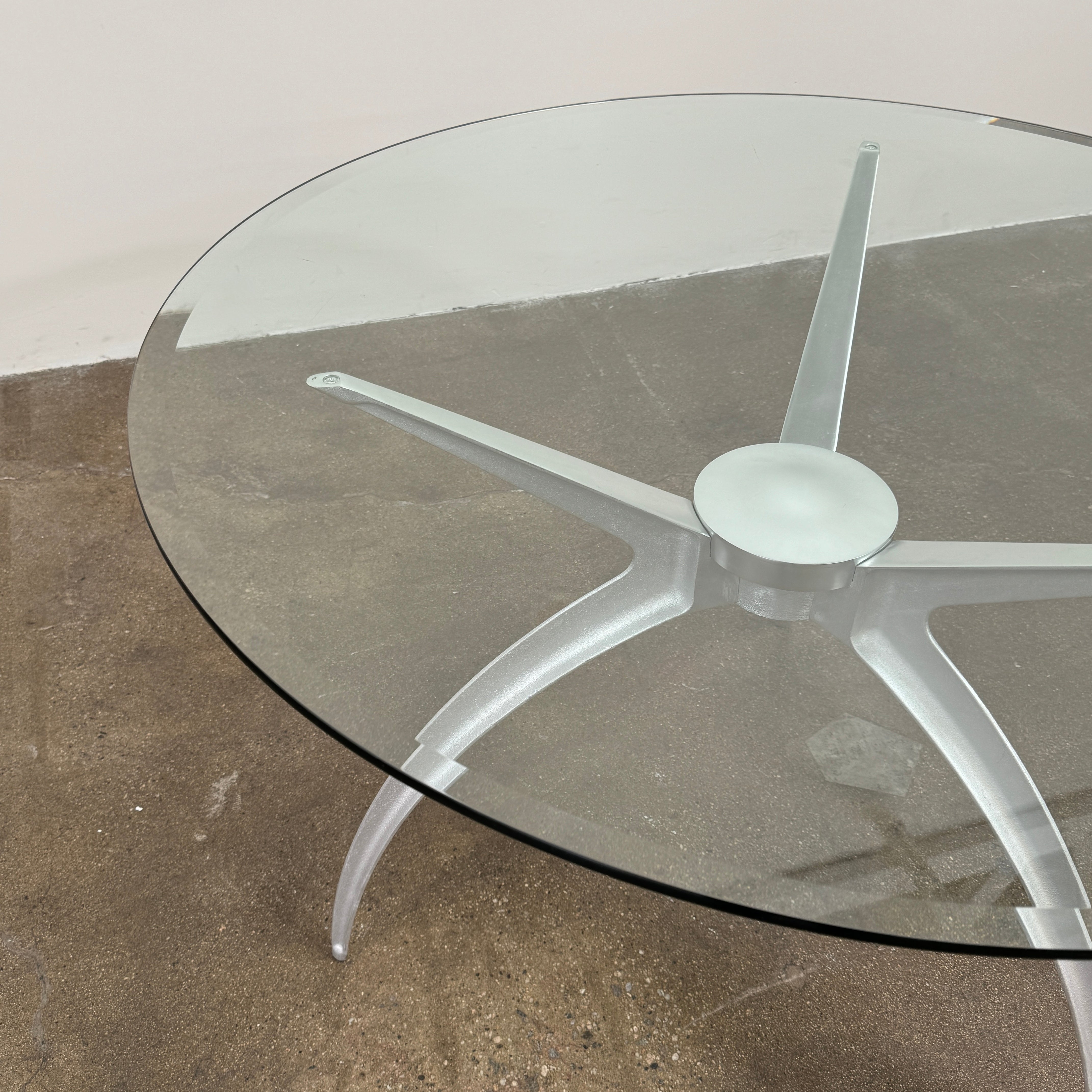Vintage BD Barcelona Arachnid Table by BD Barcelona, featuring a round glass top and three silver metallic legs, showcased on a plain white background—an eye-catching fusion of modern aesthetics and vintage elegance inspired by Pete Sans.