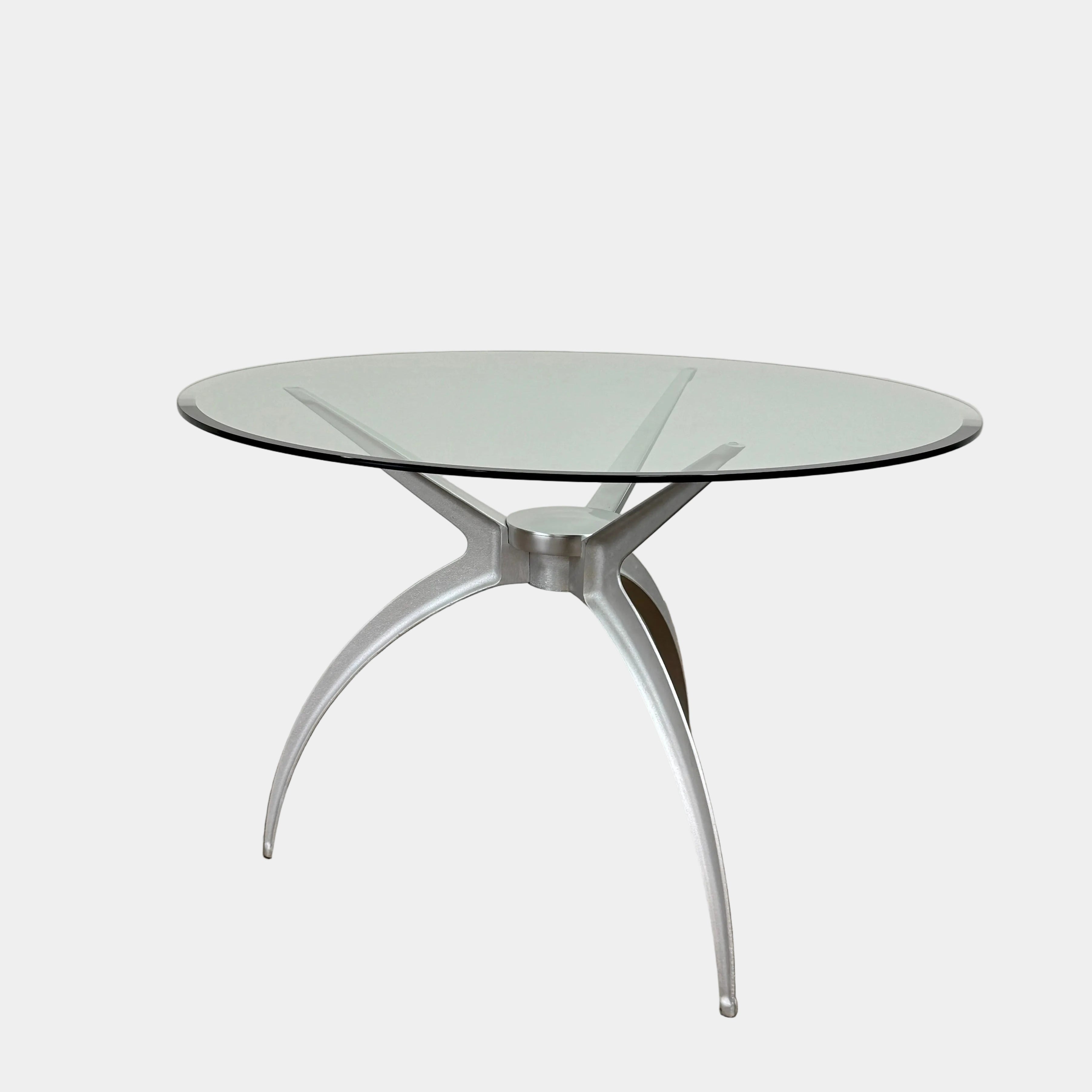Vintage BD Barcelona Arachnid Table by BD Barcelona, featuring a round glass top and three silver metallic legs, showcased on a plain white background—an eye-catching fusion of modern aesthetics and vintage elegance inspired by Pete Sans.