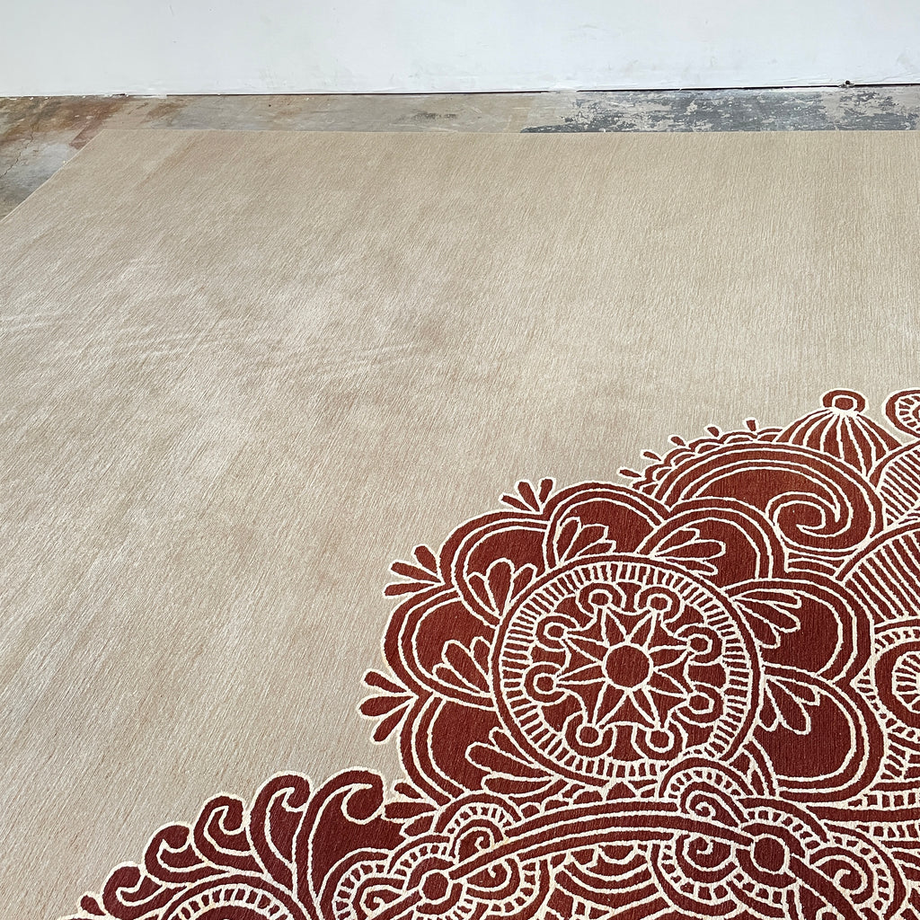 A Delinear Henna Taupe Wool 8'X10' Rug with a red and beige paisley design.