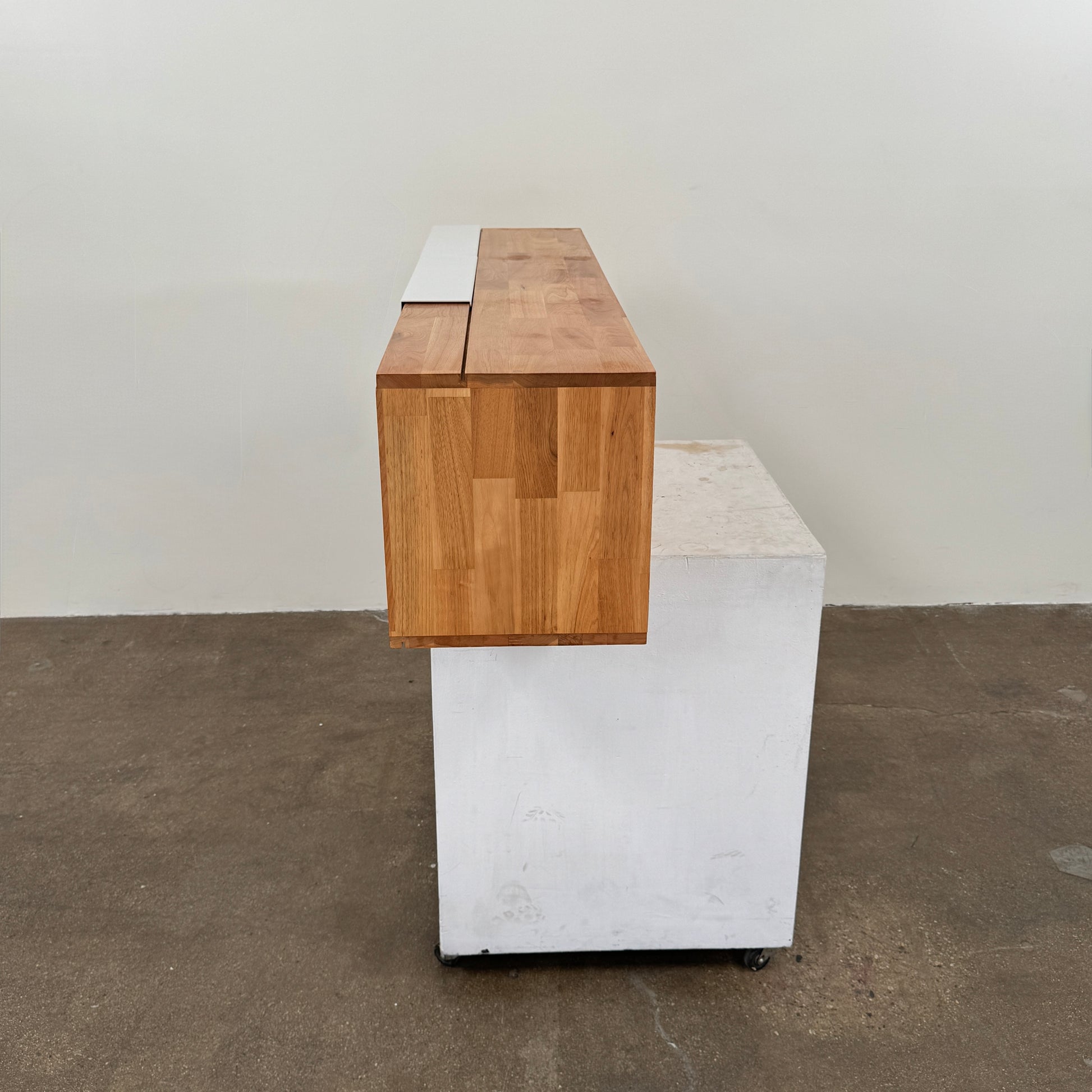 The Mash Studios LAX series 3X Wall Mounted Shelf in natural ash wood and matte white features two partially open sliding doors that reveal a solid ash wood interior, and is shown here mounted on a plain wall.