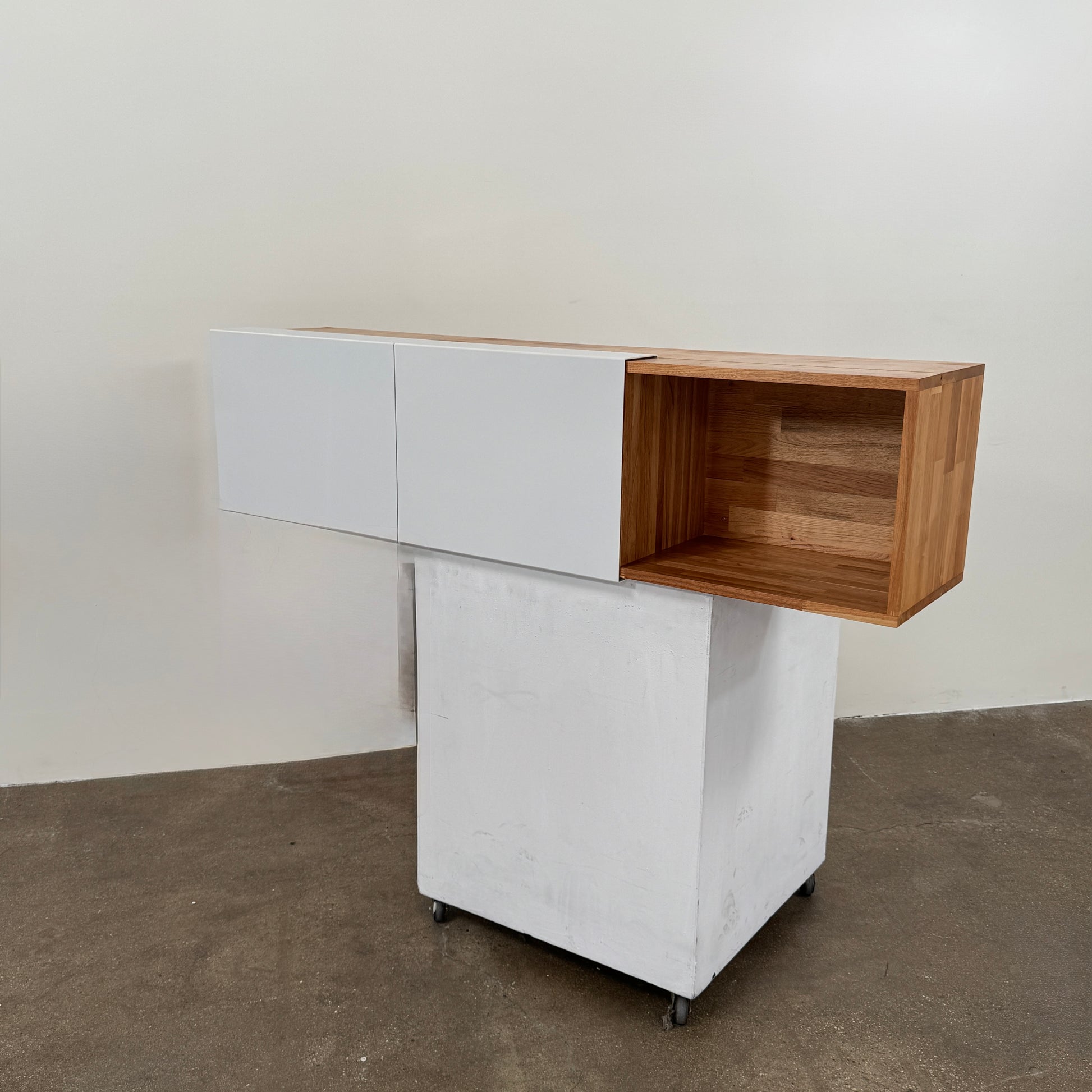 The Mash Studios LAX series 3X Wall Mounted Shelf in natural ash wood and matte white features two partially open sliding doors that reveal a solid ash wood interior, and is shown here mounted on a plain wall.