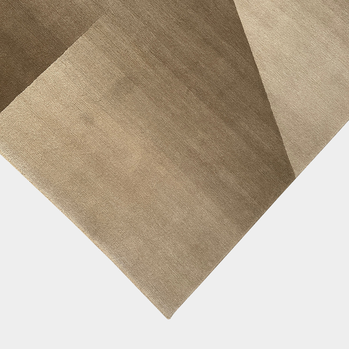 The Delinear Facet Cropped Wool Rug, offered by Delinear, is elegantly positioned on a light gray floor. It showcases modern abstract designs in beige and taupe, with diagonal lines and subtle texture.