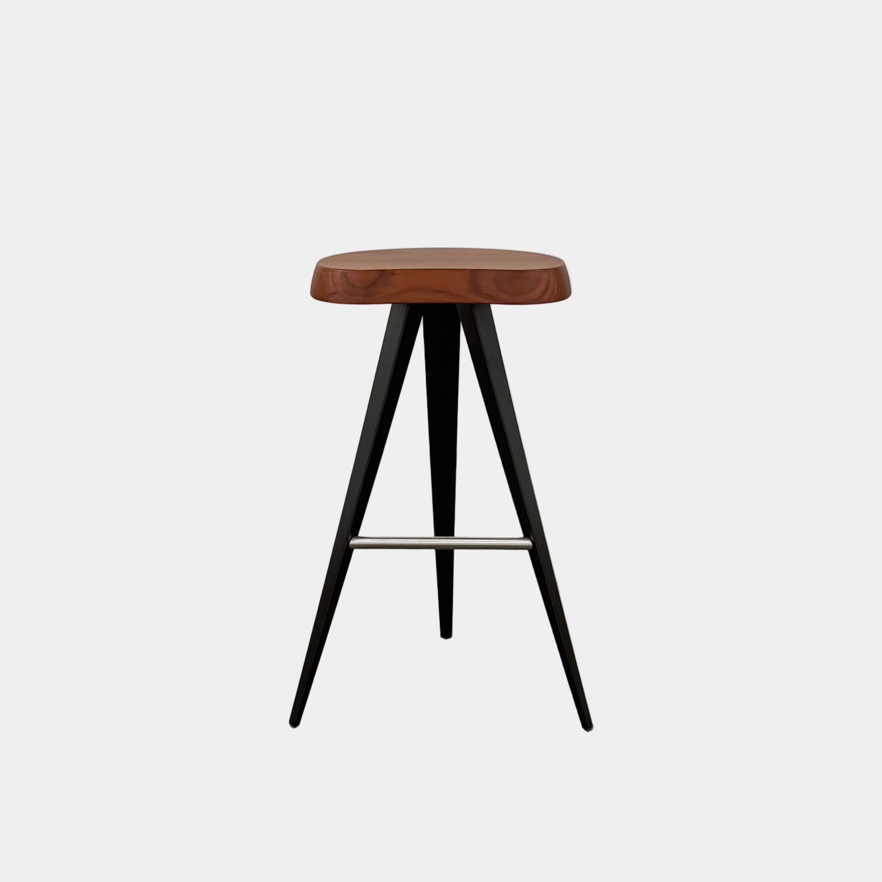 A Cassina Mexique Stool by Cassina, featuring a wooden round seat, three black angled legs, and a metal footrest, is displayed against a plain white background—highlighting its mid-century craftsmanship inspired by Charlotte Perriand.