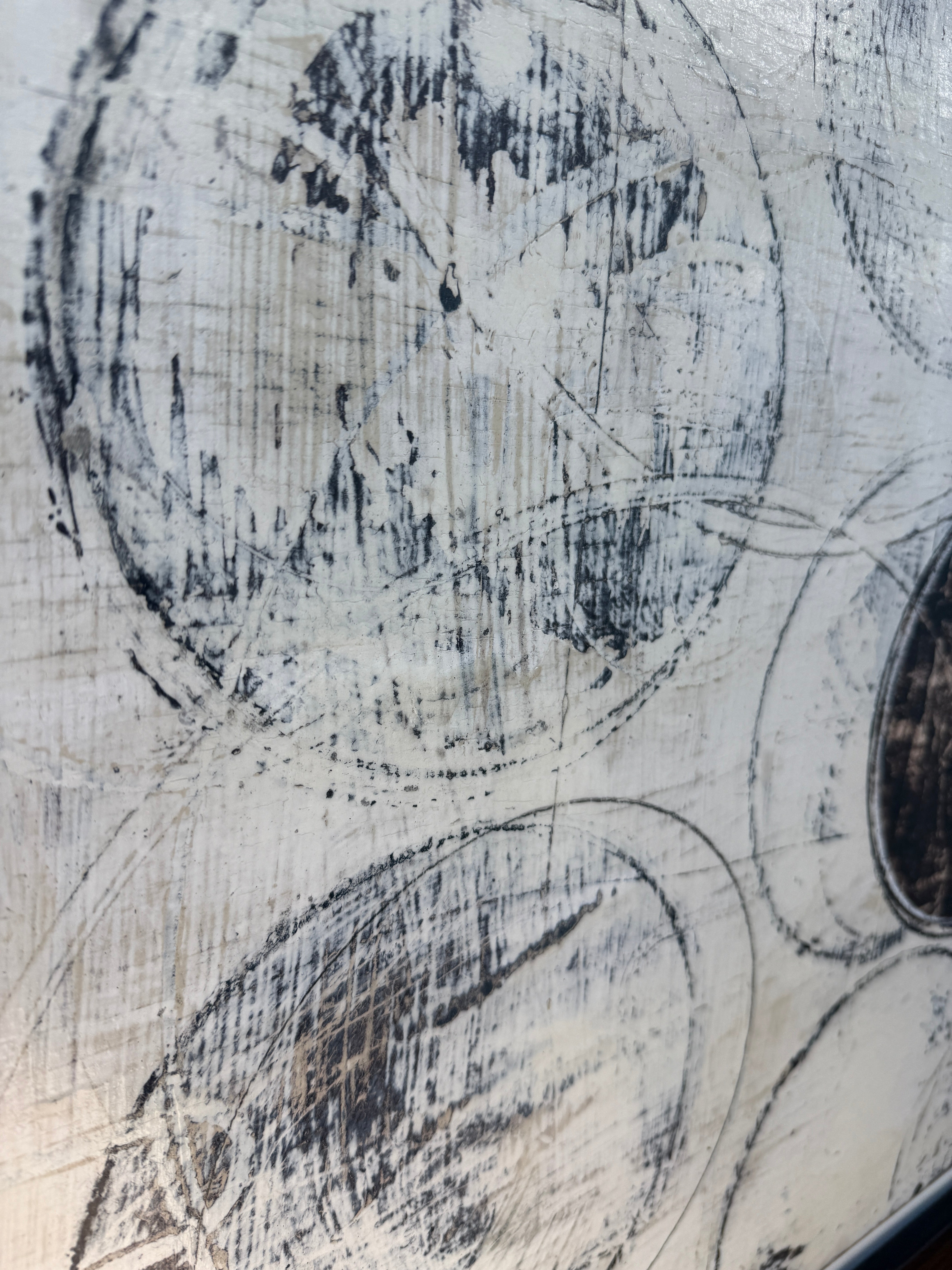 Painting: Circles by Ron Piler from Modern Resale features overlapping black and gray circles on a textured white background, displayed against a white wall on a concrete floor.