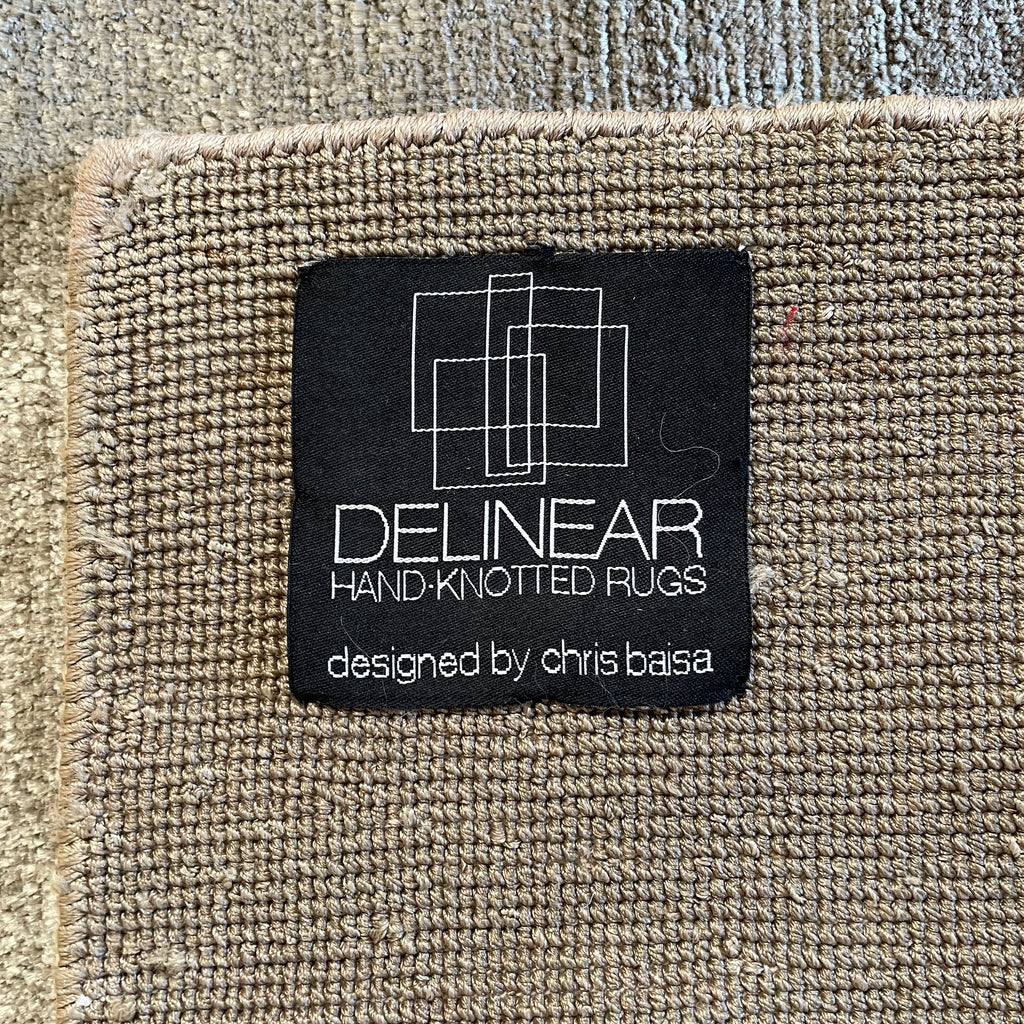A close up of a Delinear Pure Banana Silk 8'X10' Beige Rug on a white surface.