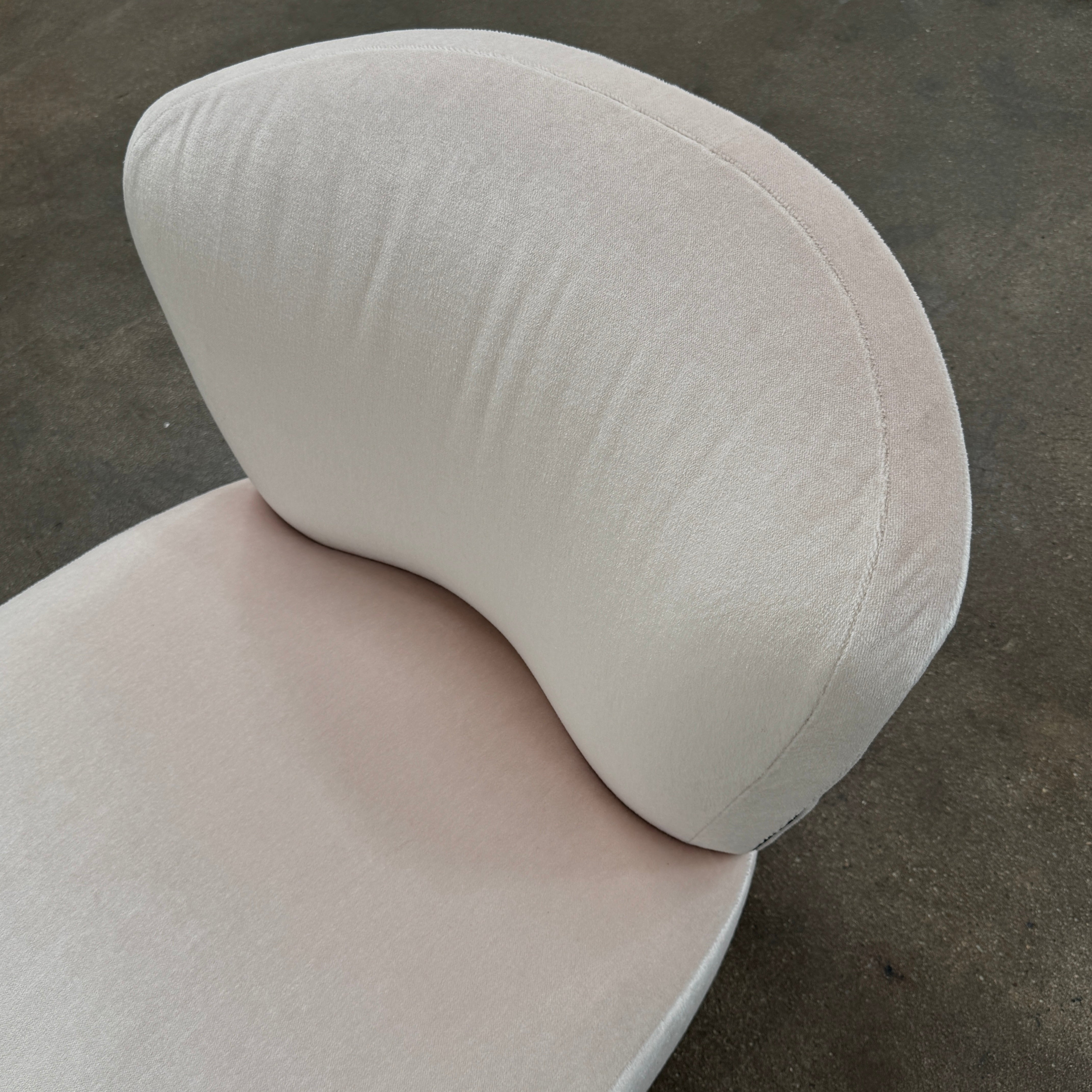 The Minotti Aston “Armchair” by Minotti features modern luxury with light pink upholstery and black wooden legs, showcased against a plain white background.