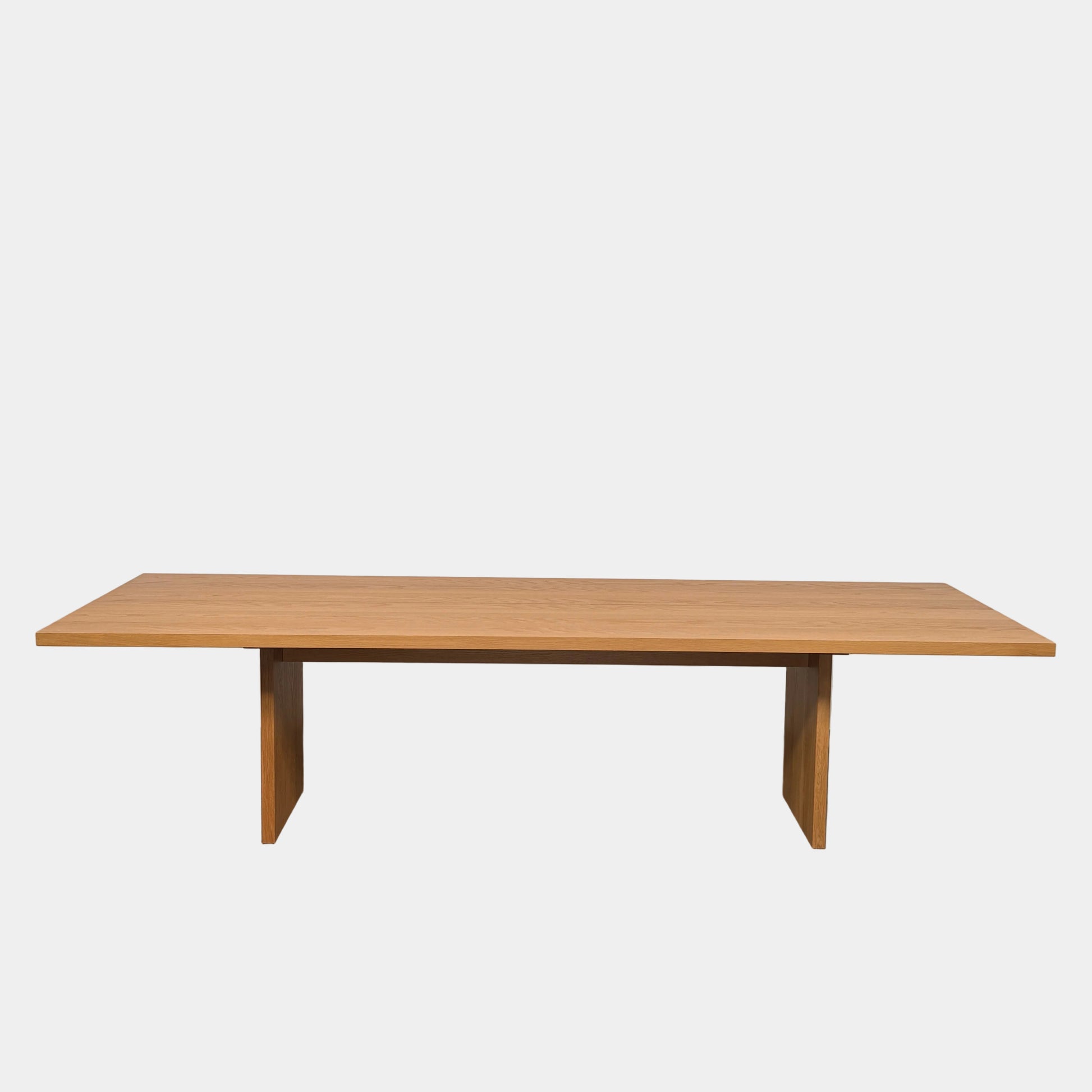A Dk3 Gather table, crafted from solid oak with a flat rectangular top and two wide, flat legs at each end, is set against a plain white background.