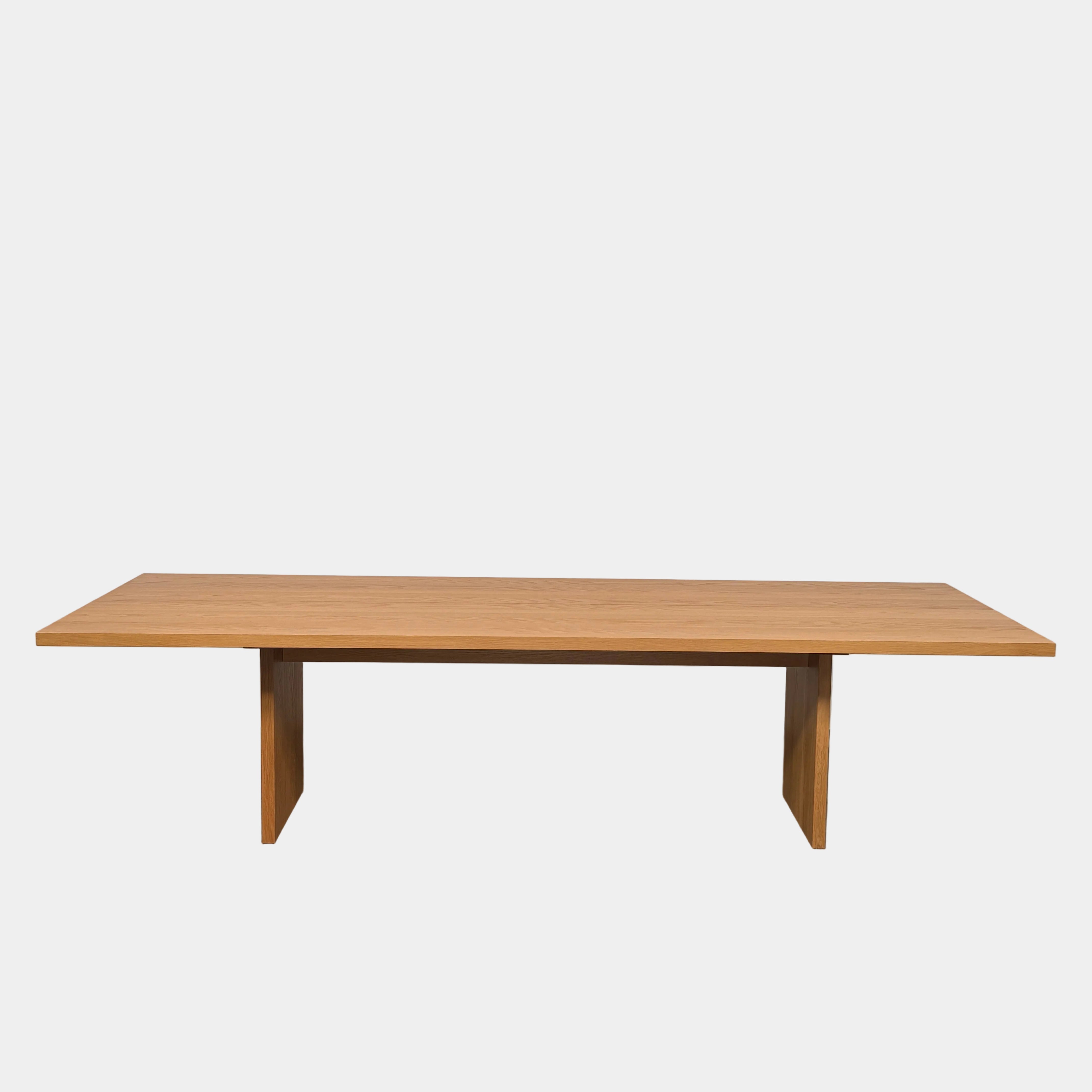 A Dk3 Gather table, crafted from solid oak with a flat rectangular top and two wide, flat legs at each end, is set against a plain white background.