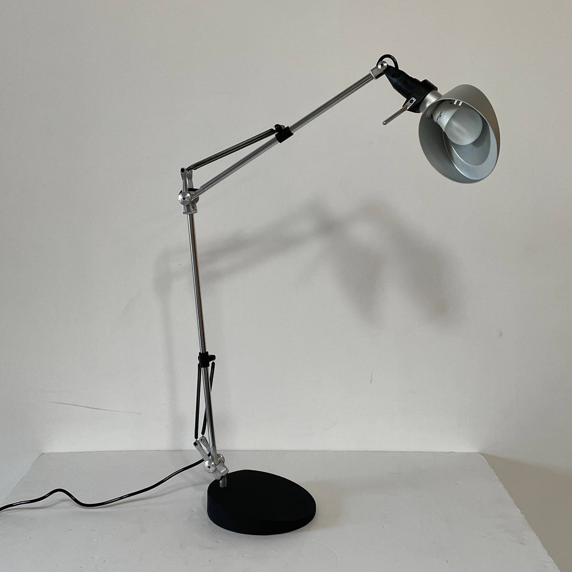 A Fontana Arte Chrono Task Lamp with a black shade and white background.