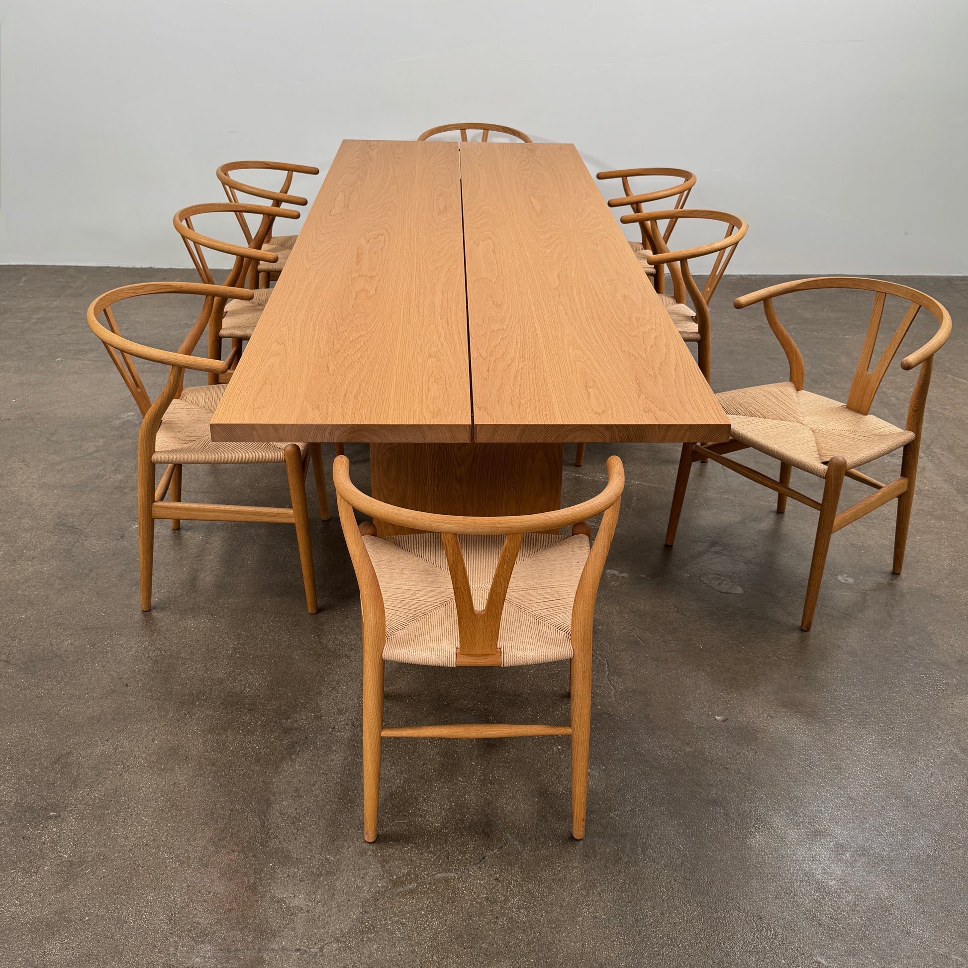 A set of two Carl Hansen & Søn Wishbone Dining Chairs by Carl Hansen & Son, featuring curved backrests and woven seats, are displayed side by side against a plain white background to highlight the renowned Danish craftsmanship inspired by Hans Wegner’s iconic design.