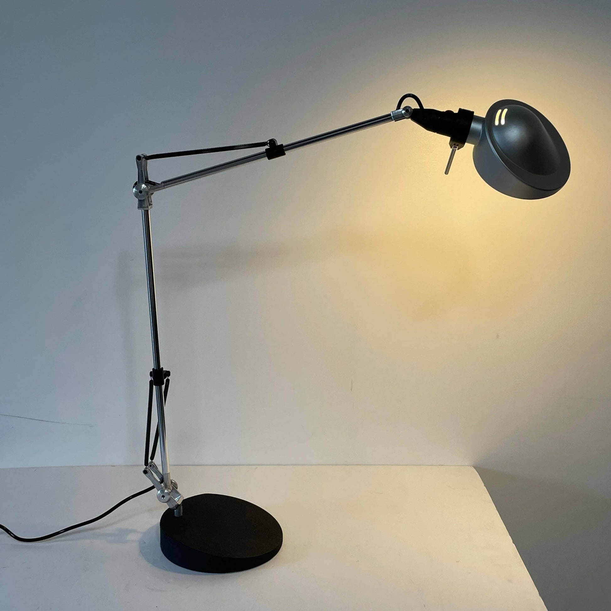 A Fontana Arte Chrono Task Lamp with a black shade and white background.