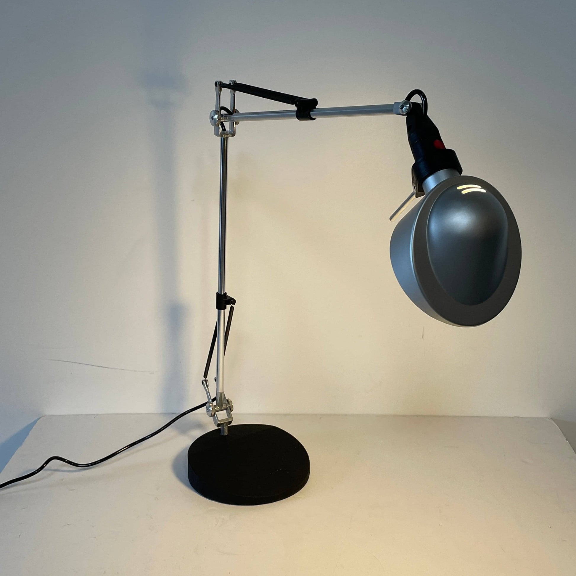 A Fontana Arte Chrono Task Lamp with a black shade and white background.