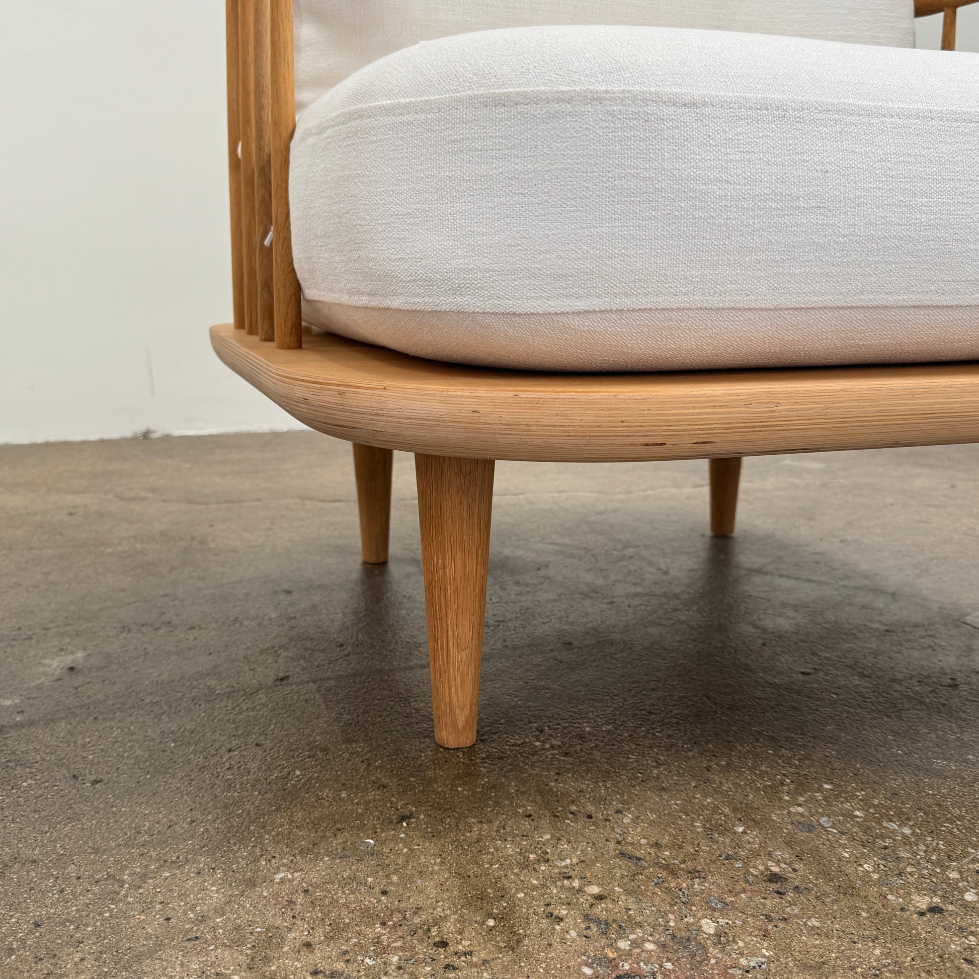 Two &Tradition FLY Lounge Chairs by Modern Resale, featuring white cushions, are arranged side by side on a bare concrete floor against a plain white wall, embodying Nordic minimalism for a refined modern interior.