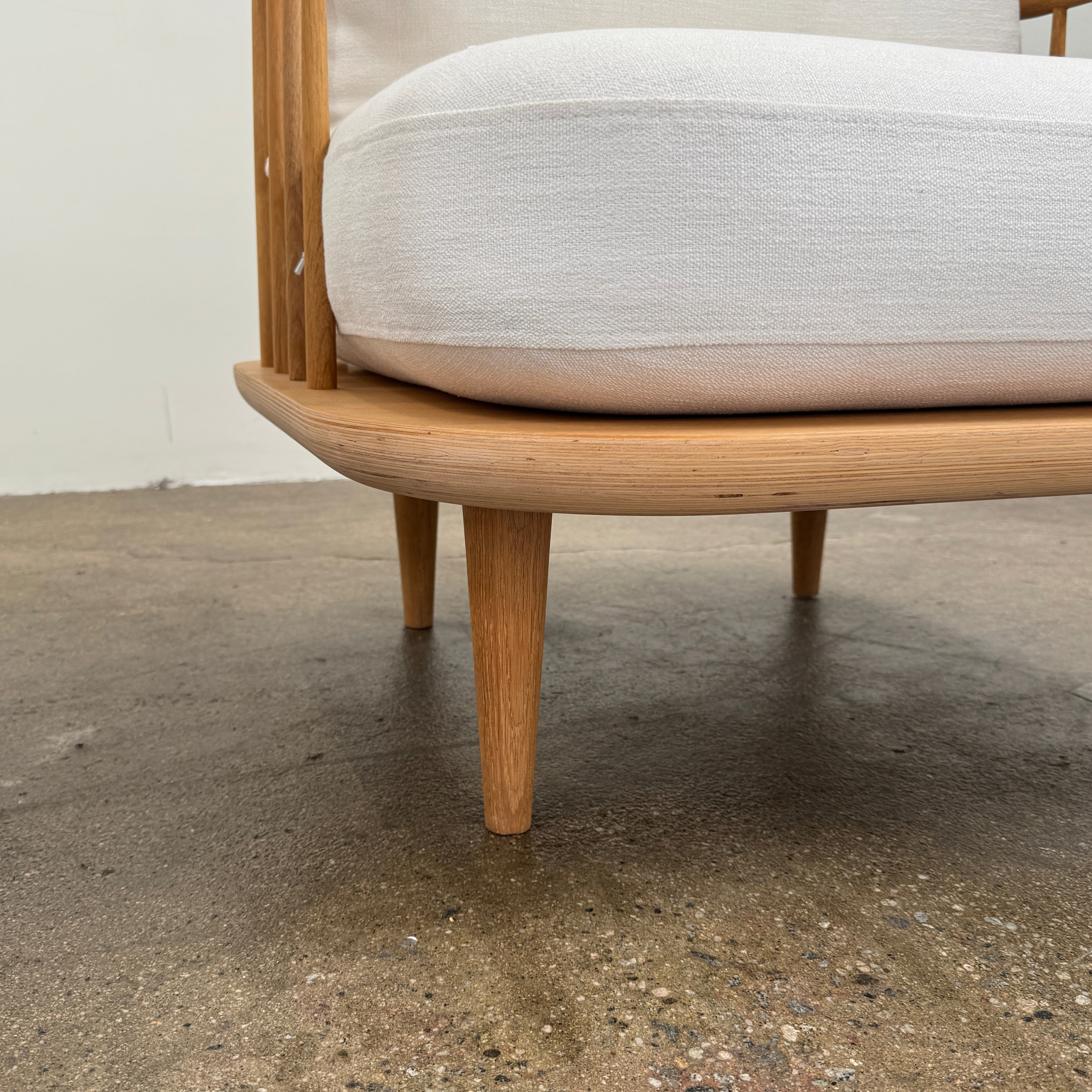 Two &Tradition FLY Lounge Chairs by Modern Resale, featuring white cushions, are arranged side by side on a bare concrete floor against a plain white wall, embodying Nordic minimalism for a refined modern interior.