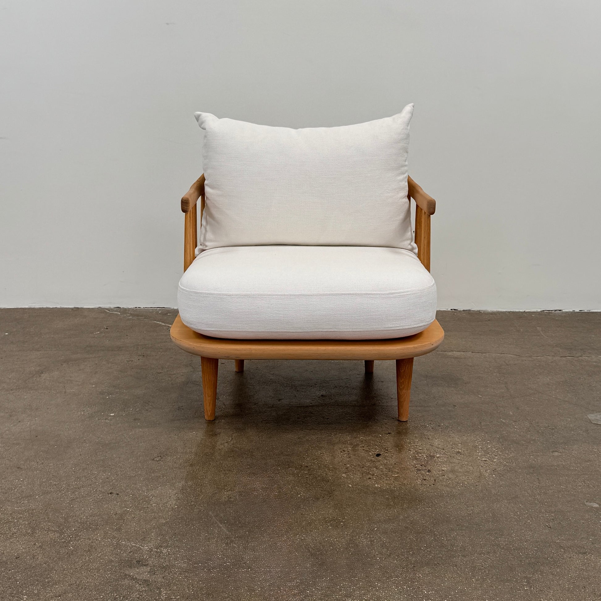 Two &Tradition FLY Lounge Chairs by Modern Resale, featuring white cushions, are arranged side by side on a bare concrete floor against a plain white wall, embodying Nordic minimalism for a refined modern interior.