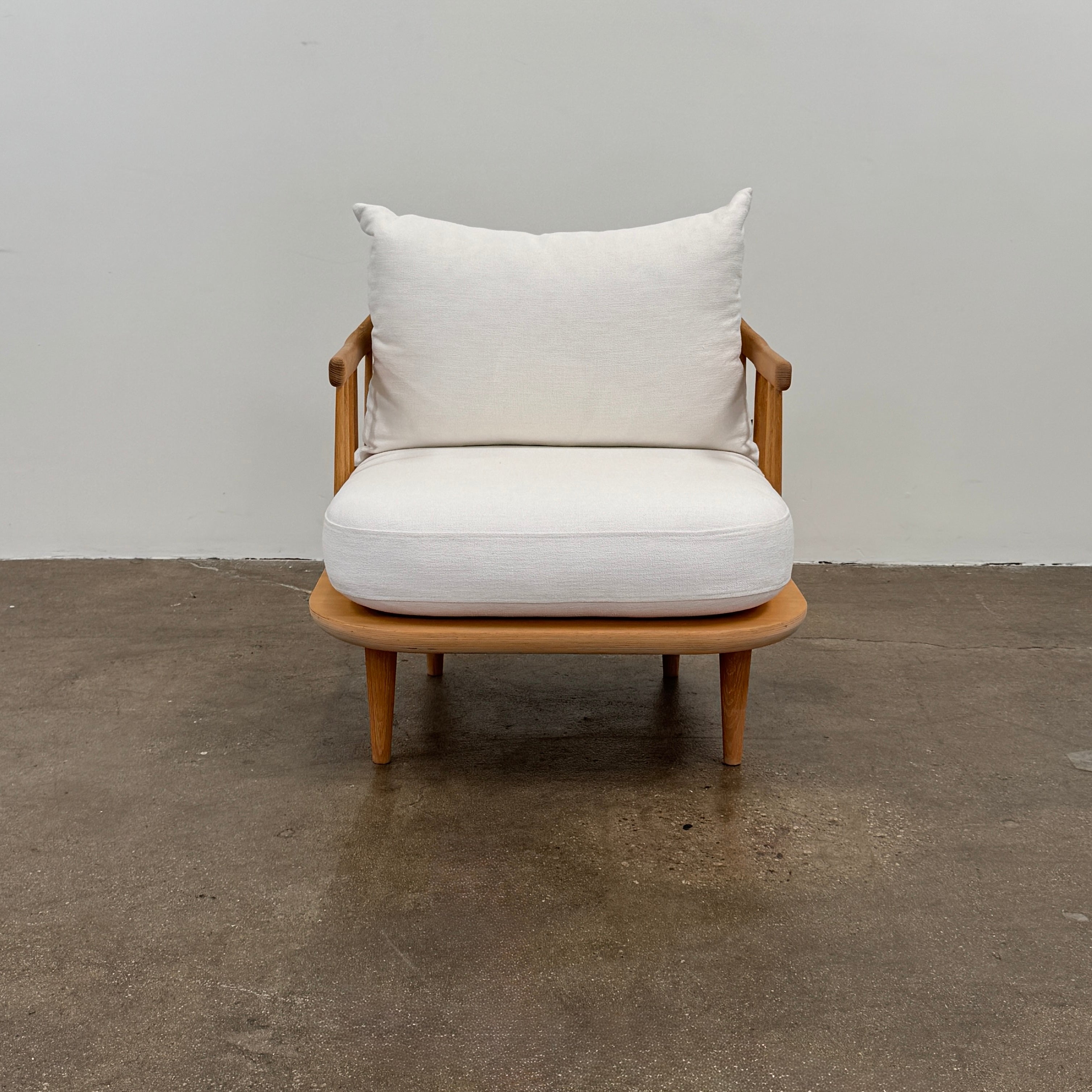 Two &Tradition FLY Lounge Chairs by Modern Resale, featuring white cushions, are arranged side by side on a bare concrete floor against a plain white wall, embodying Nordic minimalism for a refined modern interior.