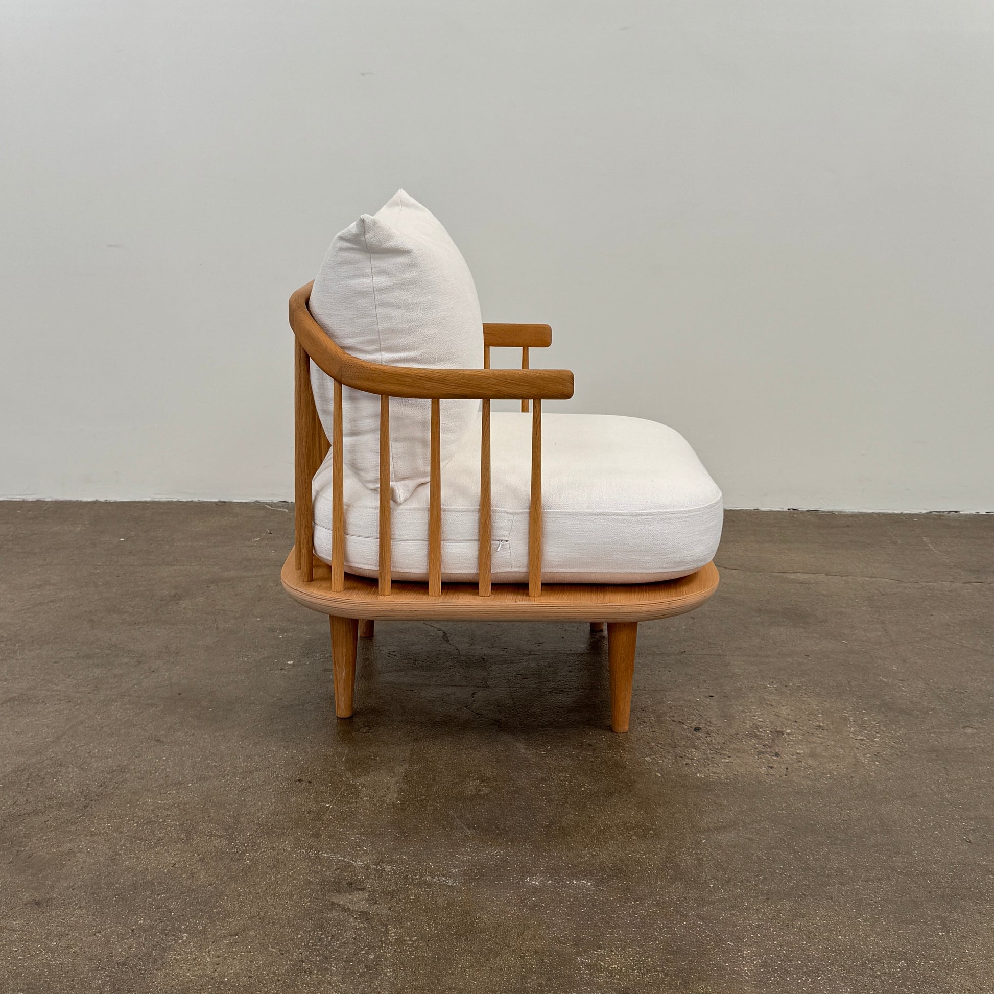 Two &Tradition FLY Lounge Chairs by Modern Resale, featuring white cushions, are arranged side by side on a bare concrete floor against a plain white wall, embodying Nordic minimalism for a refined modern interior.