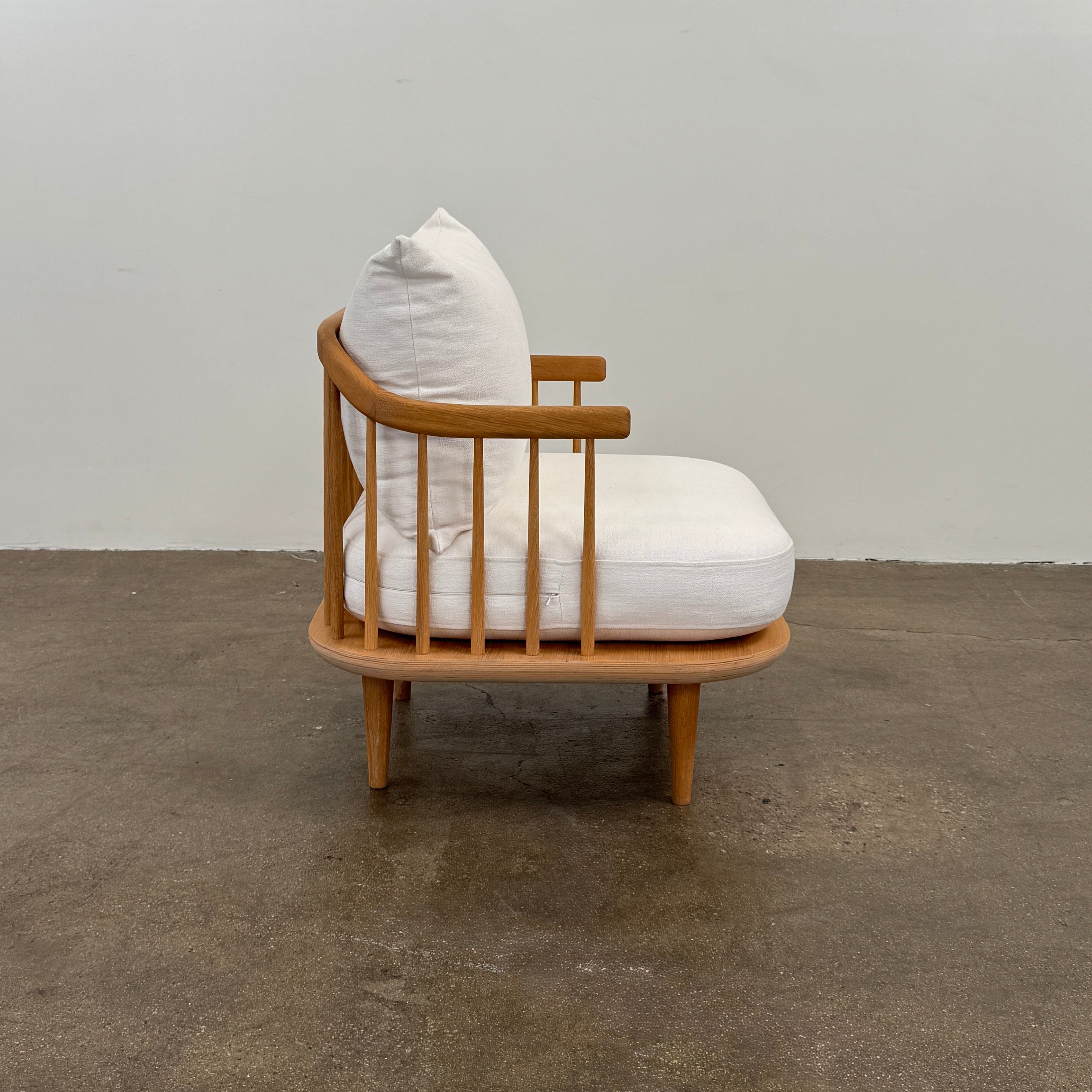 Two &Tradition FLY Lounge Chairs by Modern Resale, featuring white cushions, are arranged side by side on a bare concrete floor against a plain white wall, embodying Nordic minimalism for a refined modern interior.