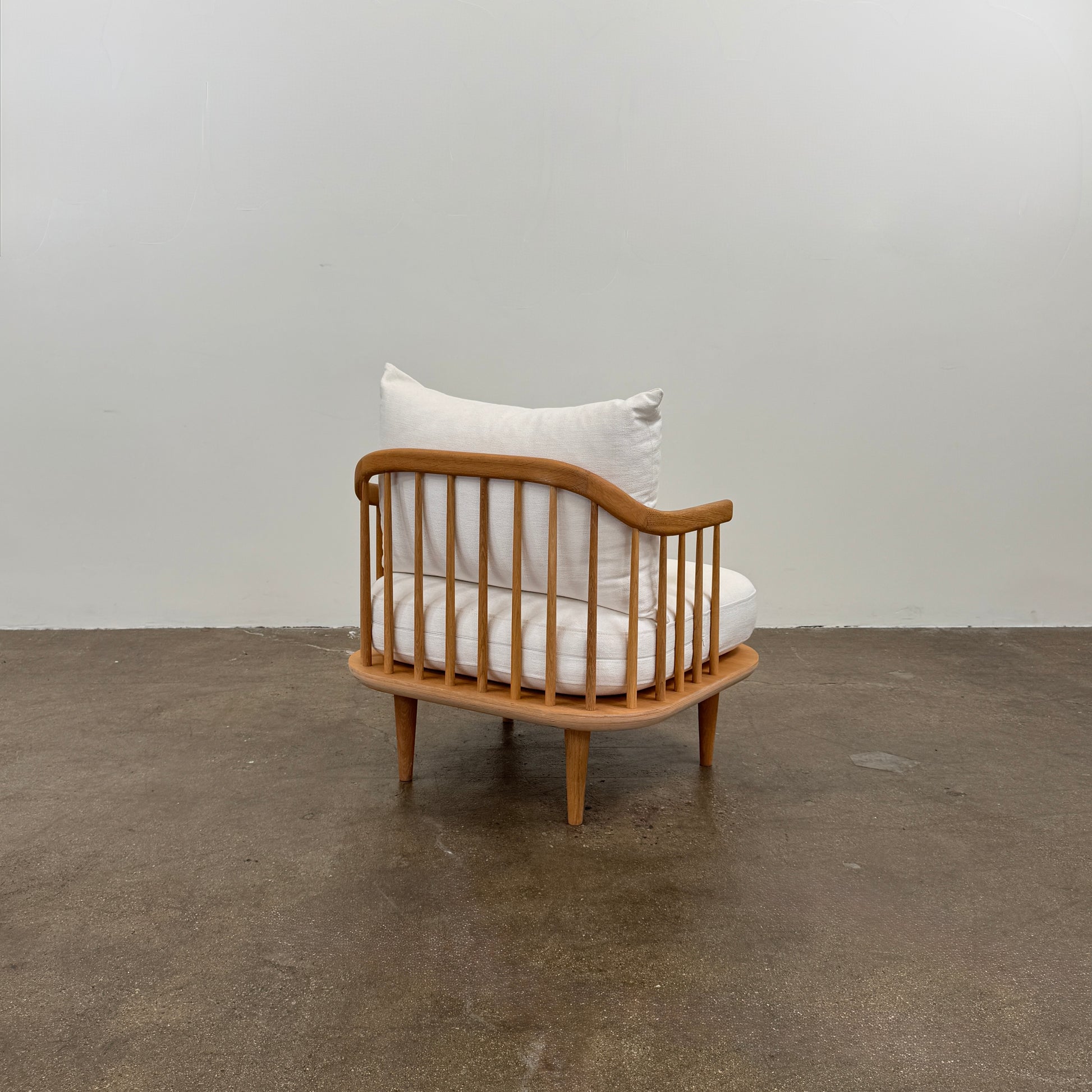Two &Tradition FLY Lounge Chairs by Modern Resale, featuring white cushions, are arranged side by side on a bare concrete floor against a plain white wall, embodying Nordic minimalism for a refined modern interior.
