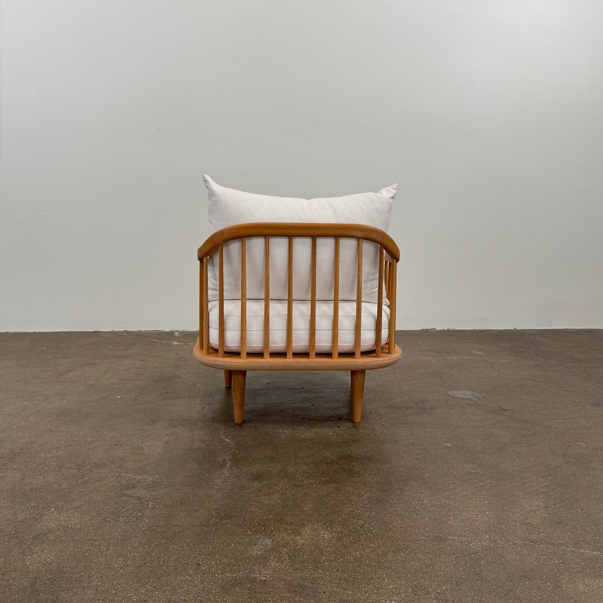 Two &Tradition FLY Lounge Chairs by Modern Resale, featuring white cushions, are arranged side by side on a bare concrete floor against a plain white wall, embodying Nordic minimalism for a refined modern interior.