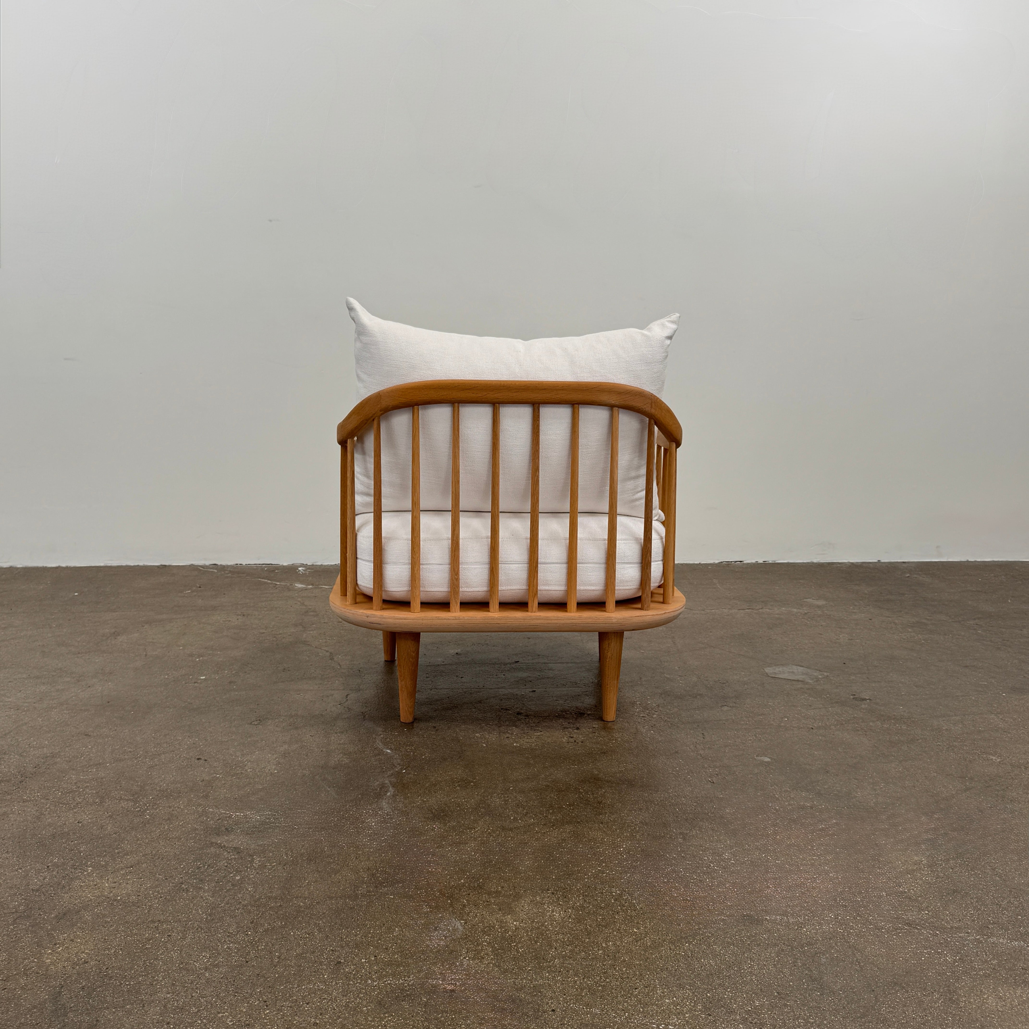 Two &Tradition FLY Lounge Chairs by Modern Resale, featuring white cushions, are arranged side by side on a bare concrete floor against a plain white wall, embodying Nordic minimalism for a refined modern interior.
