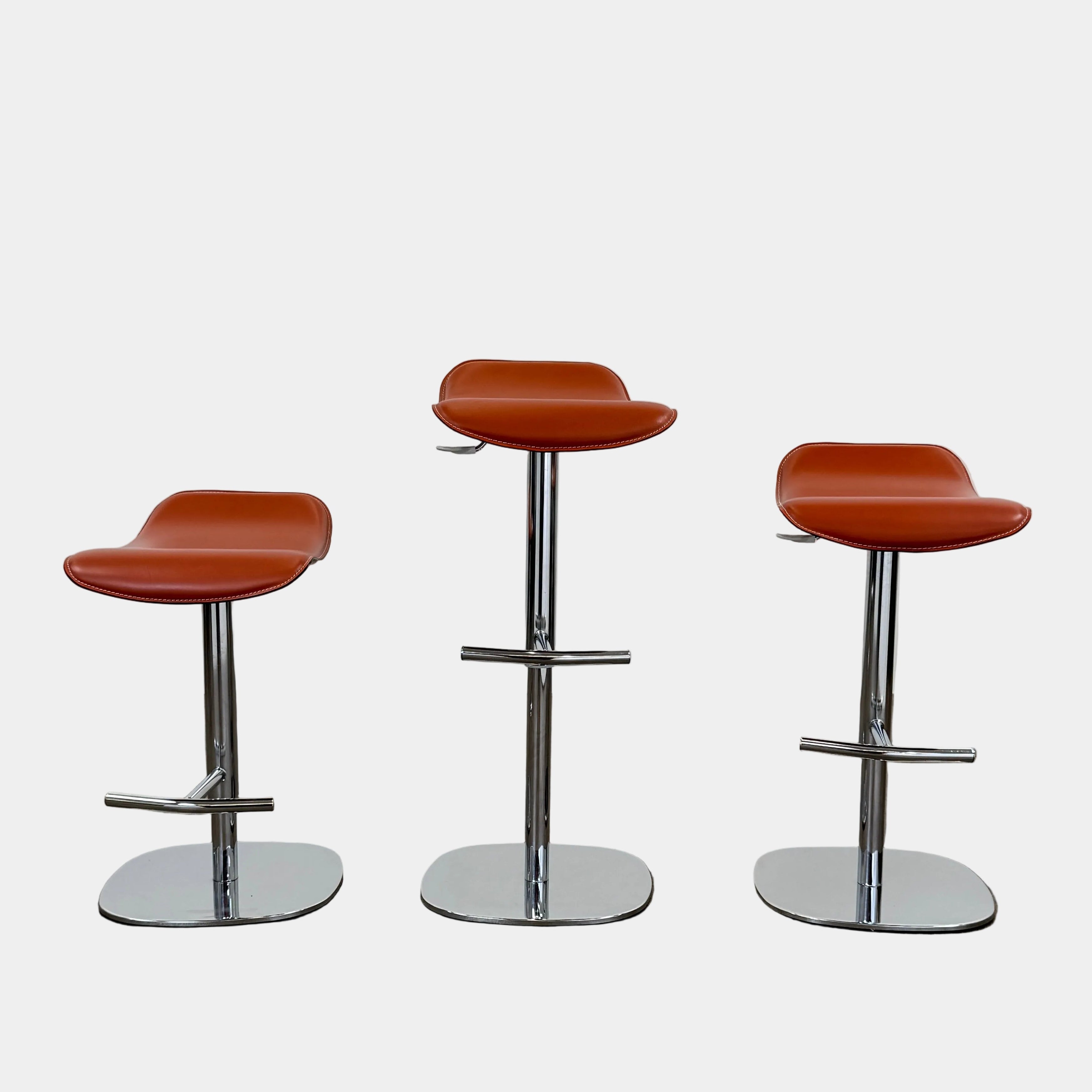 A set of three Giorgetti Ode Pneumatic Stools, featuring rich red-brown seats and sleek chrome bases, by luxury brand Giorgetti, are arranged in a row against a plain white background—exemplifying the refined elegance of Italian furniture design.