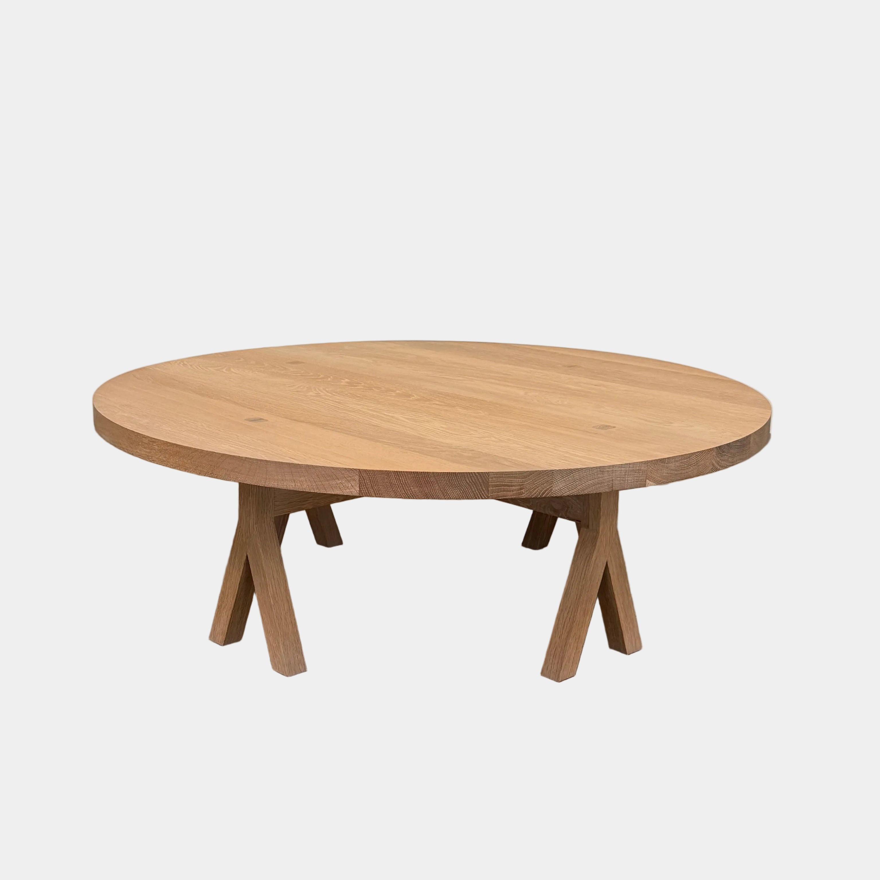 The De La Espada Commune Coffee Table 772, crafted by De La Espada from solid oiled oak, features a smooth round top and four angled legs. Displayed against a plain white background, it is ideal for enhancing communal living spaces.