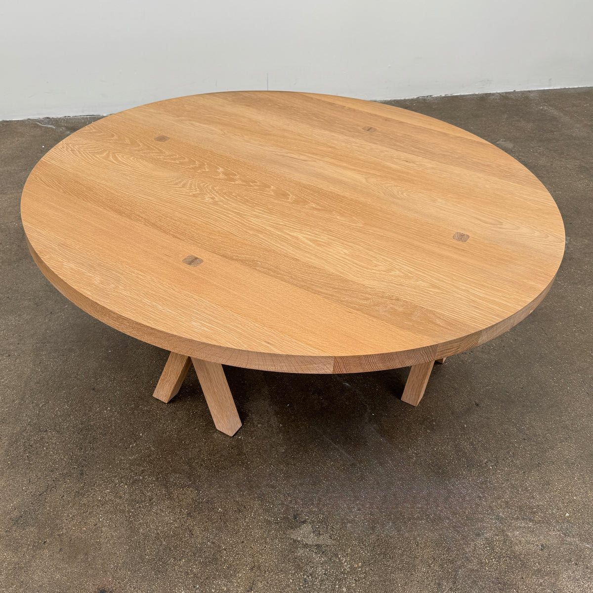 The De La Espada Commune Coffee Table 772, crafted by De La Espada from solid oiled oak, features a smooth round top and four angled legs. Displayed against a plain white background, it is ideal for enhancing communal living spaces.