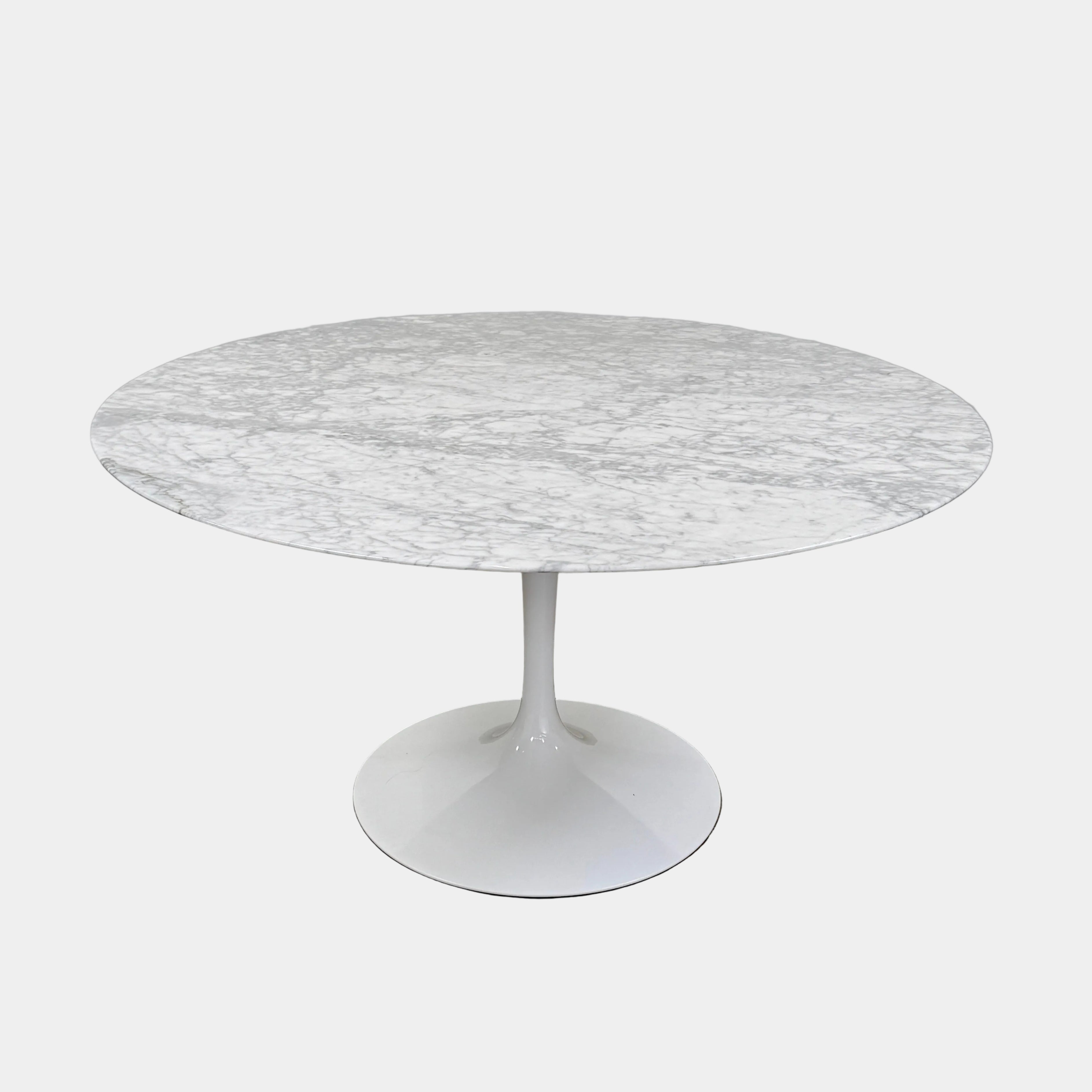 The Knoll Saarinen Table 54″ Round Arabescato Marble, designed by Knoll and inspired by the iconic Saarinen silhouette, features a single central pedestal base and is crafted from luxurious Arabescato marble. It is photographed against a plain white background.