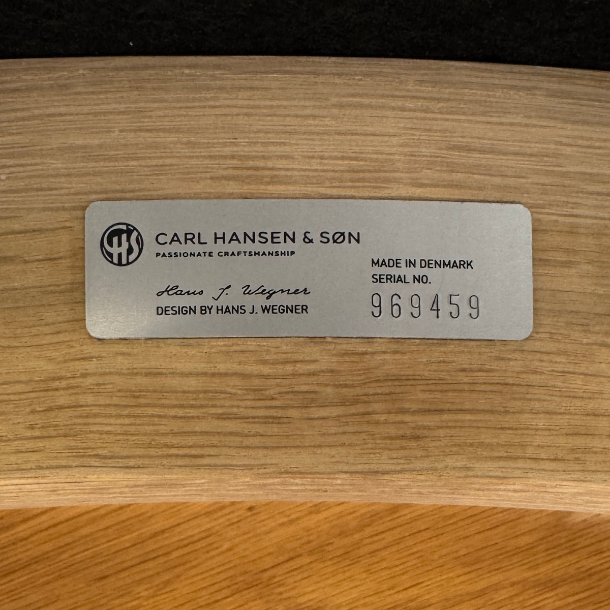 A set of five Carl Hansen & Son CH20 Elbow Chairs by Carl Hansen & Son, each with a curved wooden backrest and a round black seat cushion, are arranged in two rows against a plain white background.