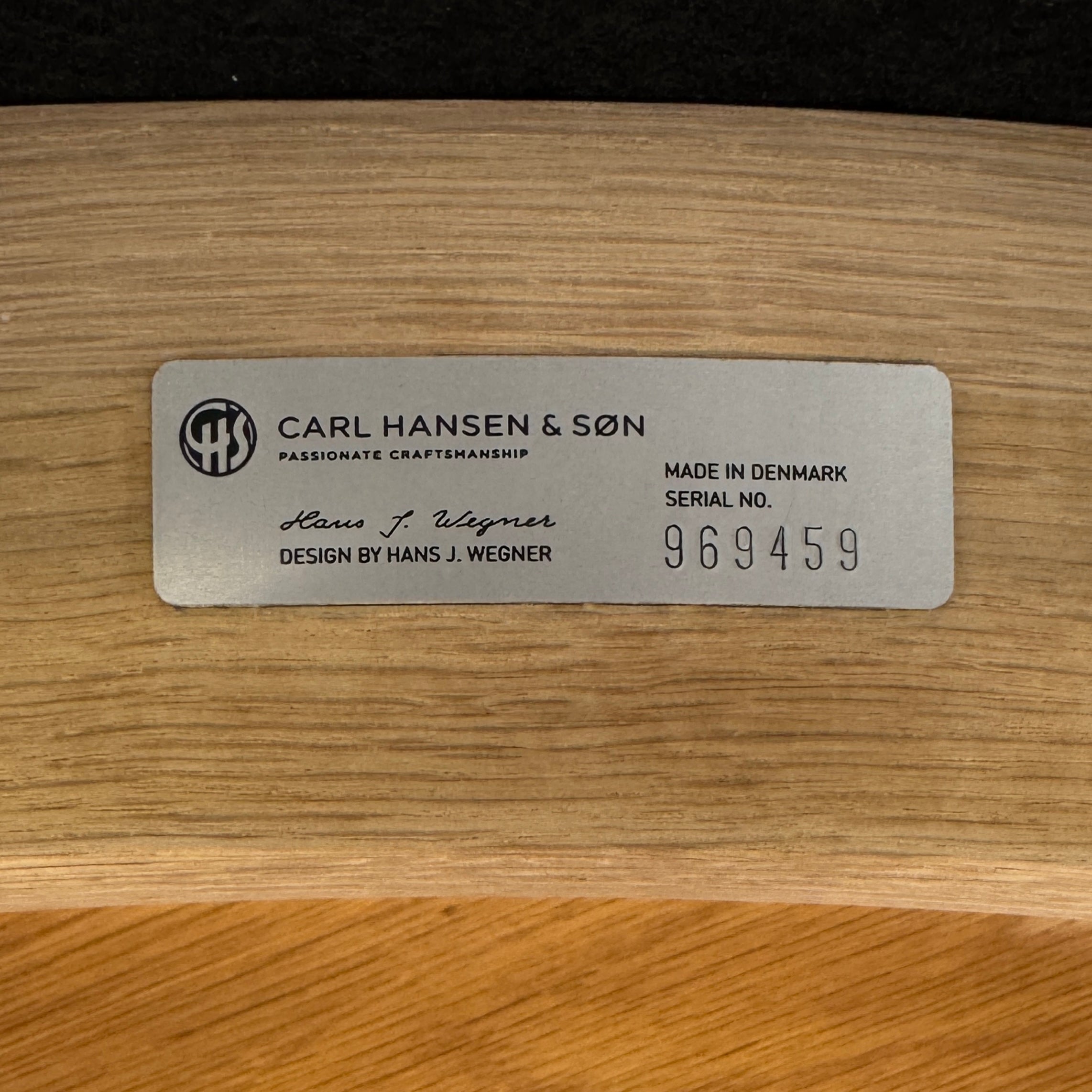 A set of five Carl Hansen & Son CH20 Elbow Chairs by Carl Hansen & Son, each with a curved wooden backrest and a round black seat cushion, are arranged in two rows against a plain white background.