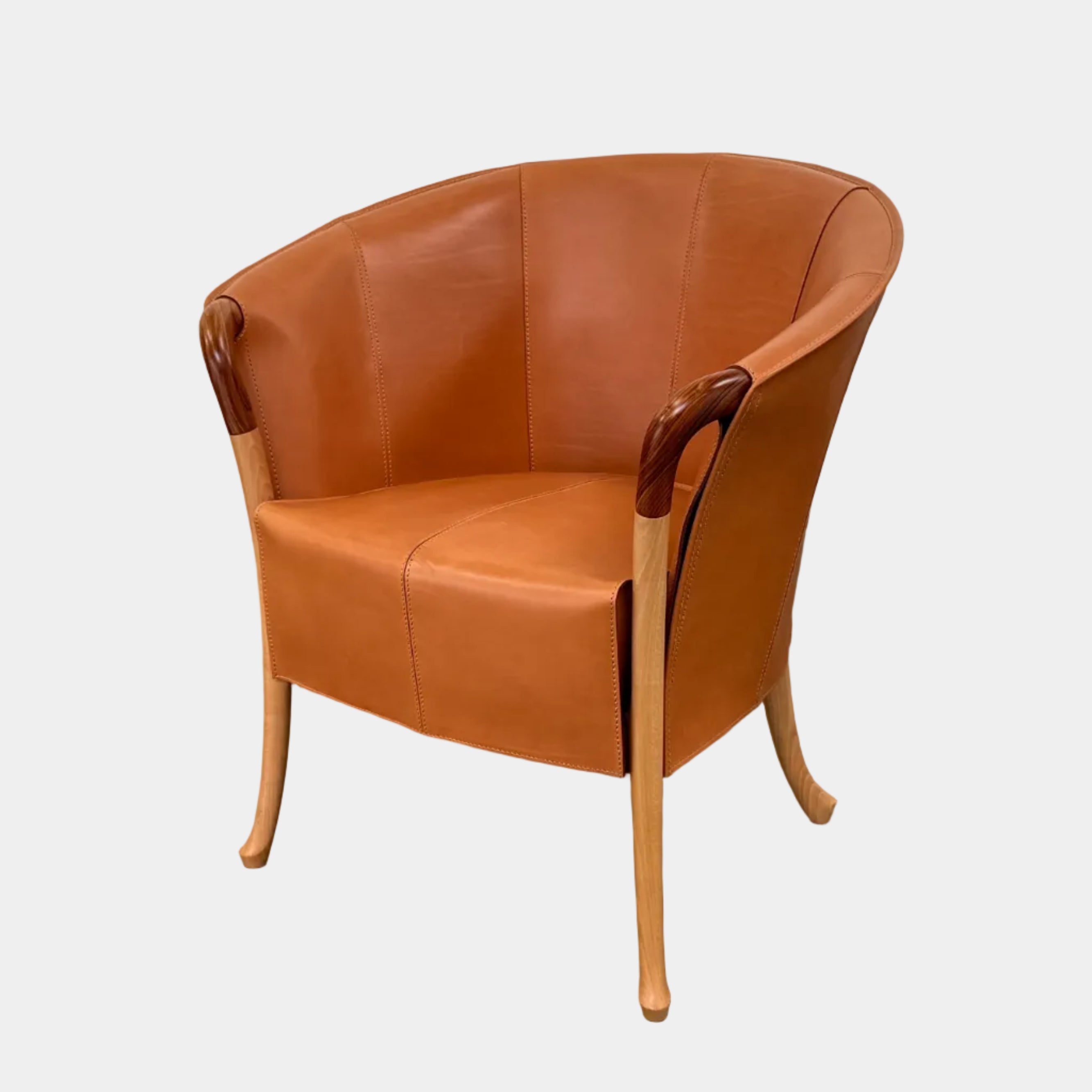 The Giorgetti “Progetti” Armchair by Giorgetti features a brown saddle leather seat, wooden legs, and Pau Ferro armrest accents, presented against a plain white background.