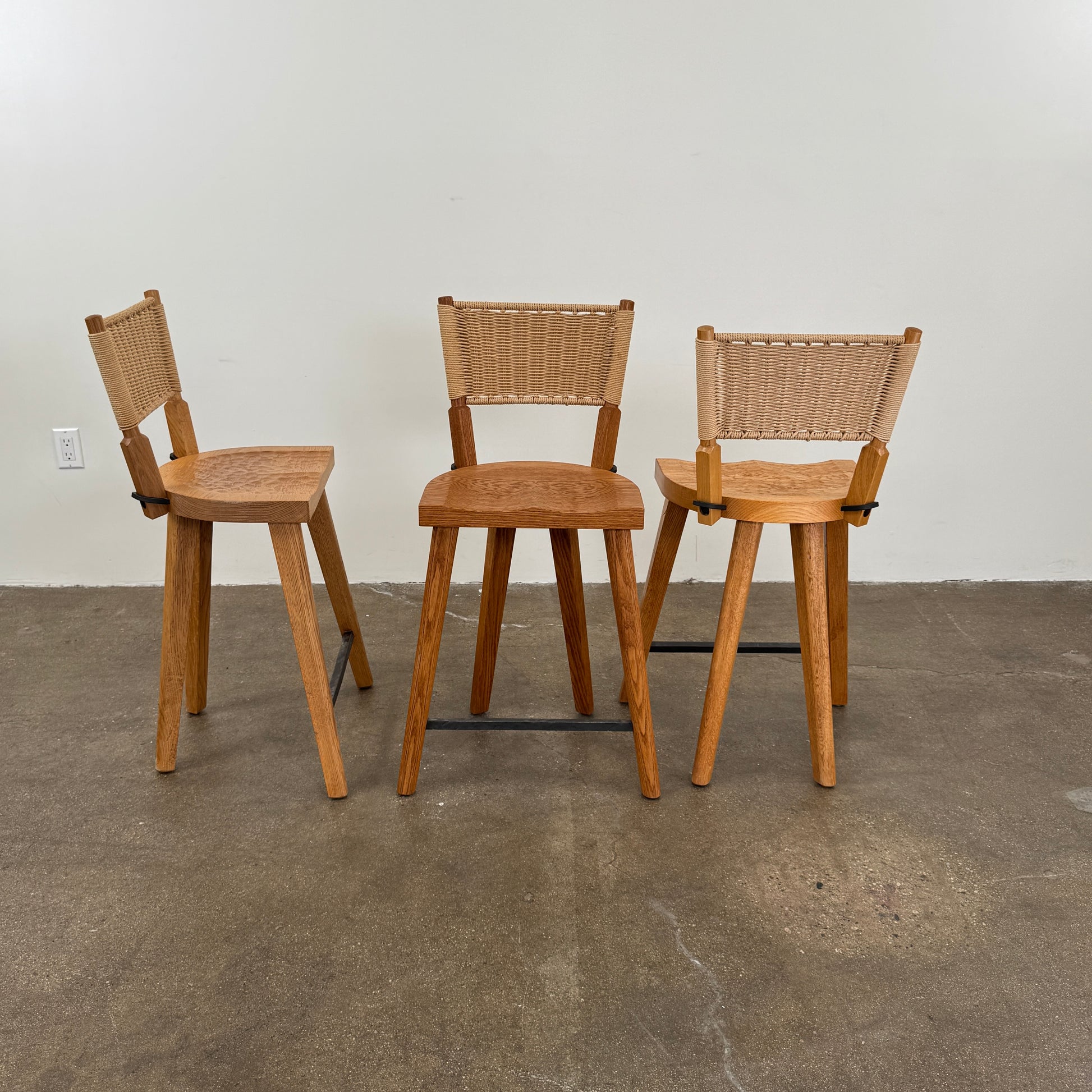 The Furniture Marolles Counter Stool Set of 3 by Furniture Marolles, featuring wooden construction and woven backrests inspired by handcrafted design, is arranged side by side against a plain white background.