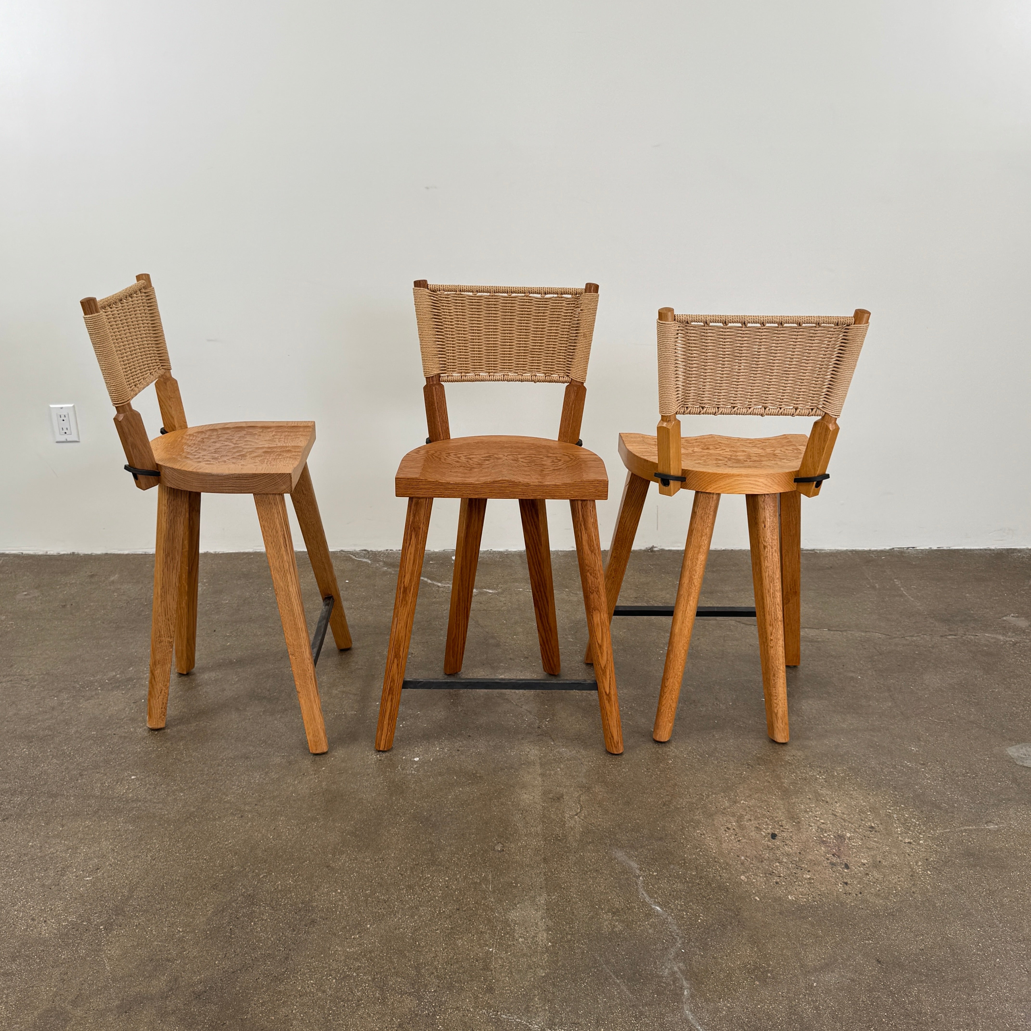 The Furniture Marolles Counter Stool Set of 3 by Furniture Marolles, featuring wooden construction and woven backrests inspired by handcrafted design, is arranged side by side against a plain white background.